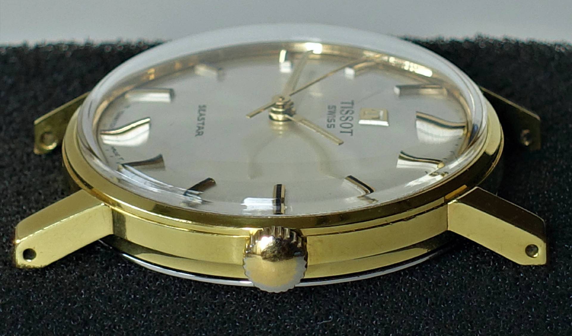 Goldfarbene Armbanduhr mit hellem Zifferblatt und goldfarbenen Zeigern.