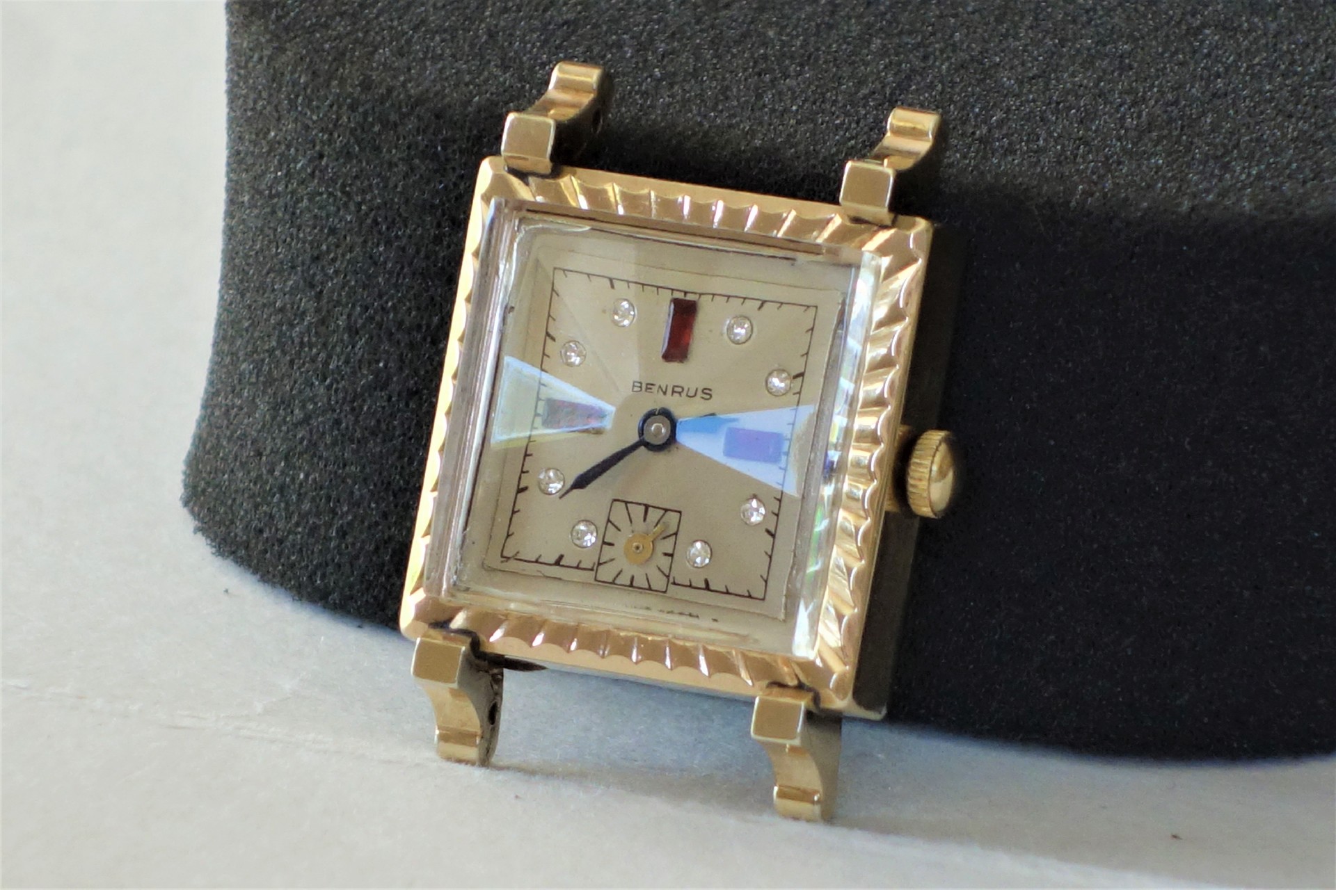 Rechteckige Armbanduhr mit hellem Zifferblatt, Metallgehäuse und aufgesetzten Indizes.