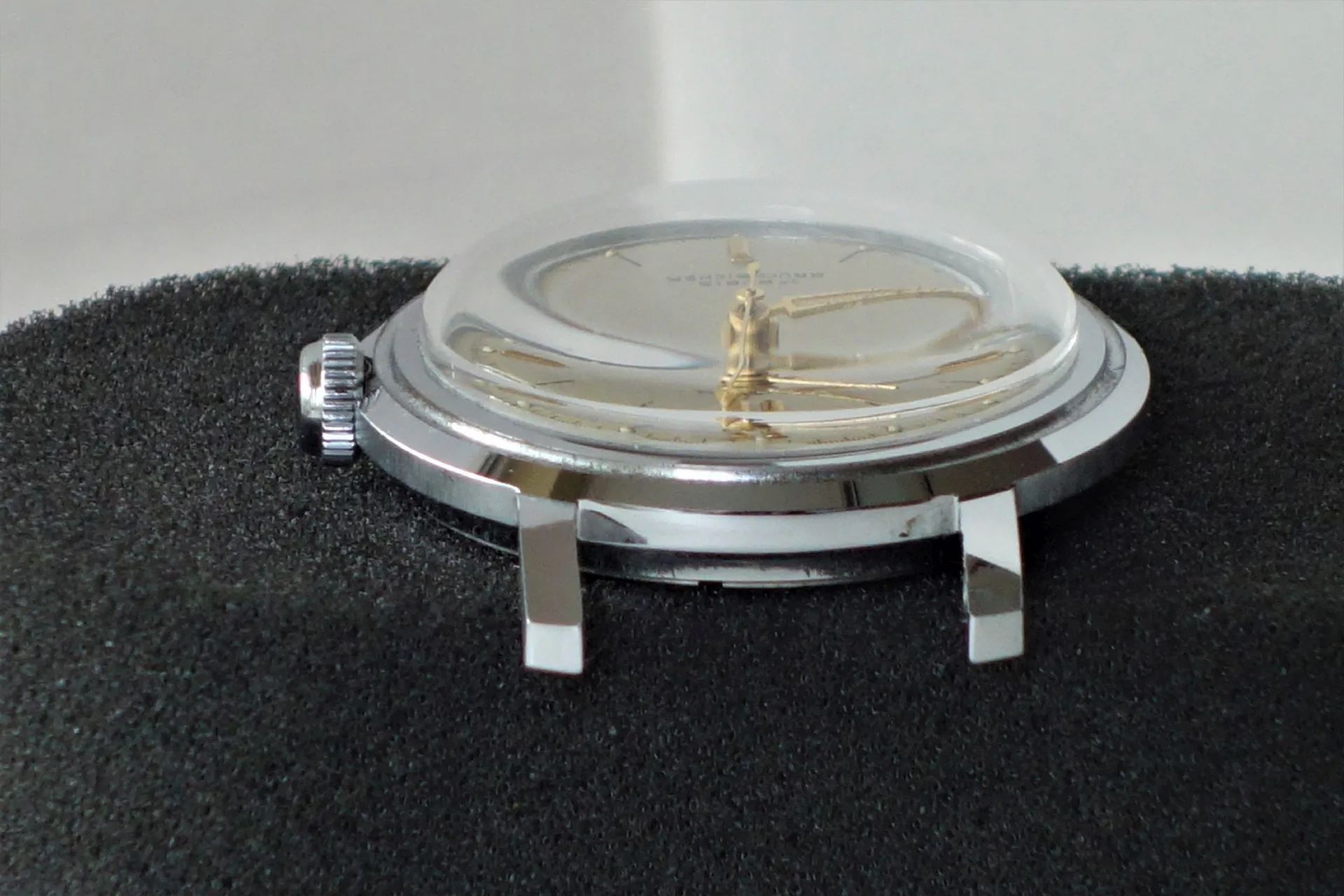 Silberne Armbanduhr Flache silberfarbene Armbanduhr mit goldfarbenen Zeigern und gewölbtem Glas.