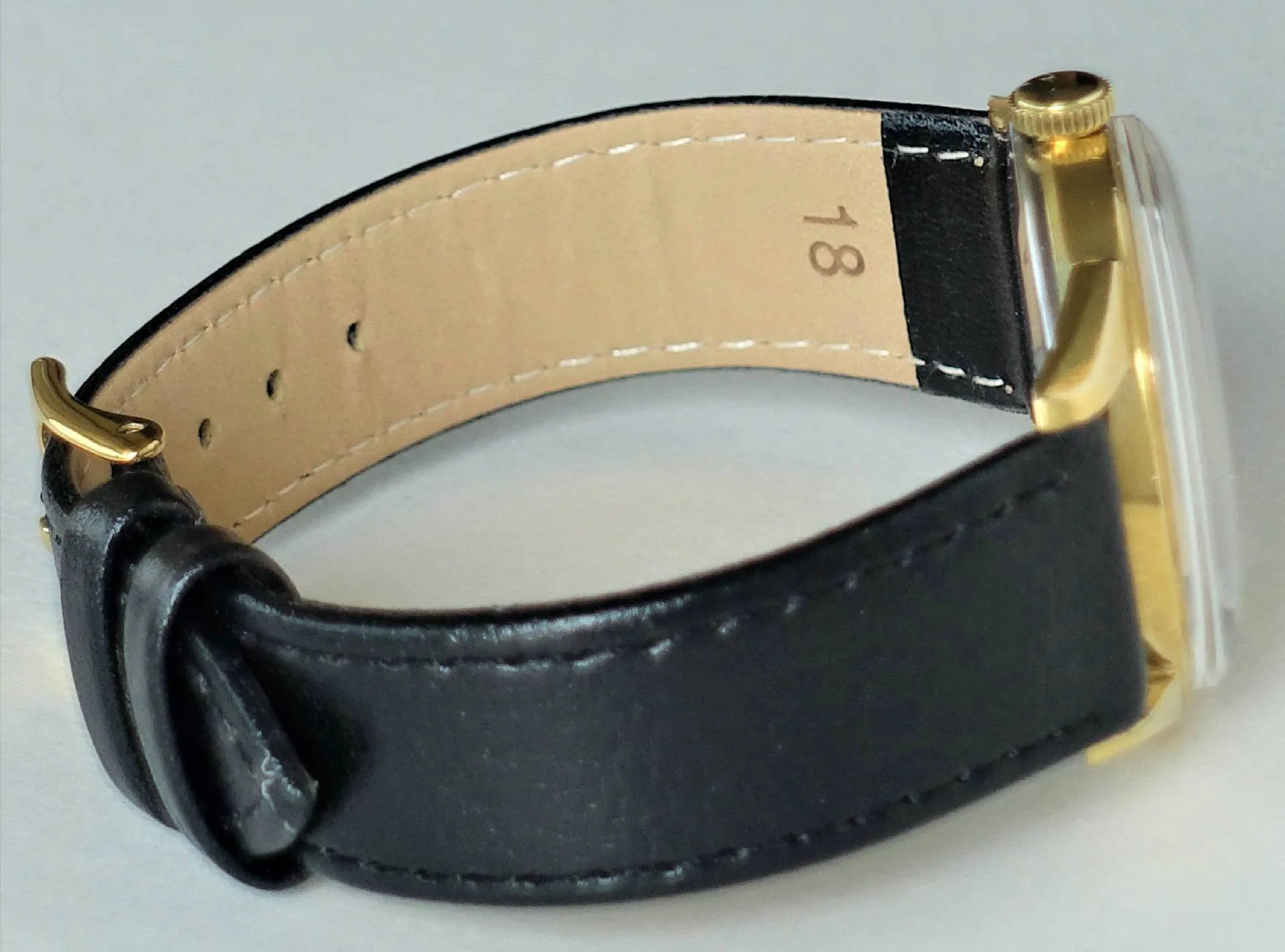 Armbanduhr schwarz goldfarben Schwarze Armbanduhr mit goldfarbenem Gehäuse und schwarzem Lederarmband.