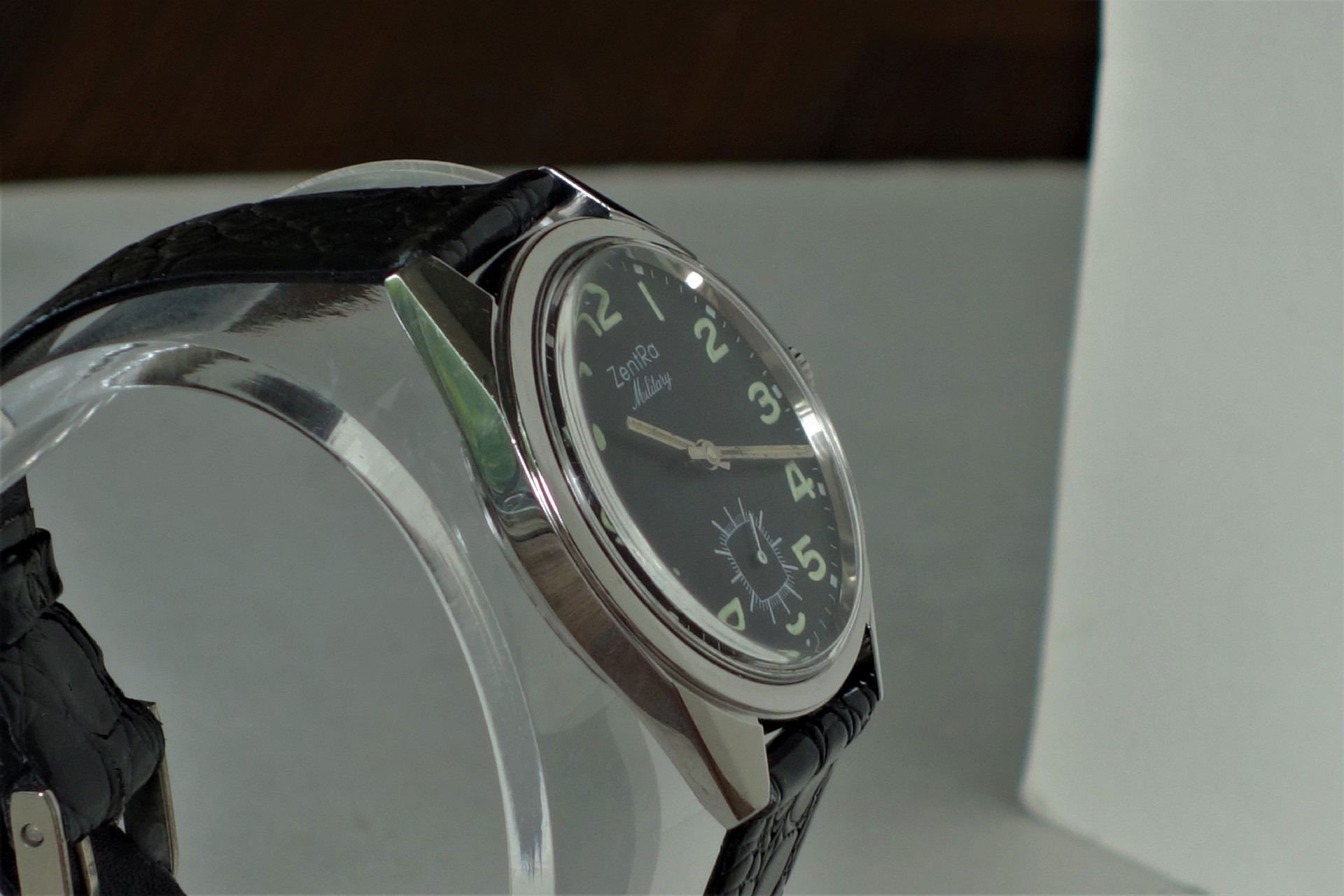 Schwarze Armbanduhr mit silberfarbenem Gehäuse und schwarzem Zifferblatt.