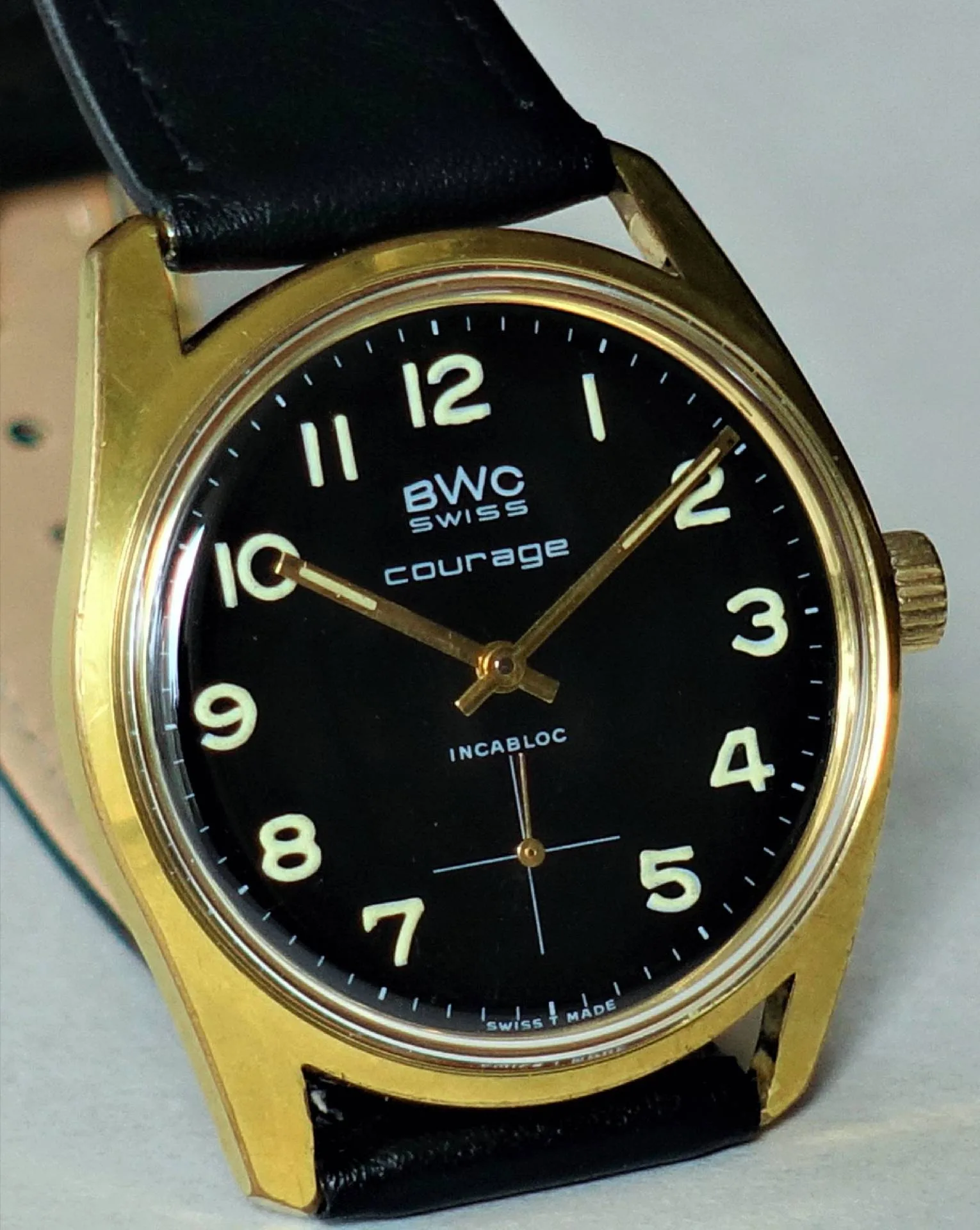 BWC Armbanduhr schwarz gold Schwarze Armbanduhr mit goldfarbenem Gehäuse und schwarzem Lederarmband.