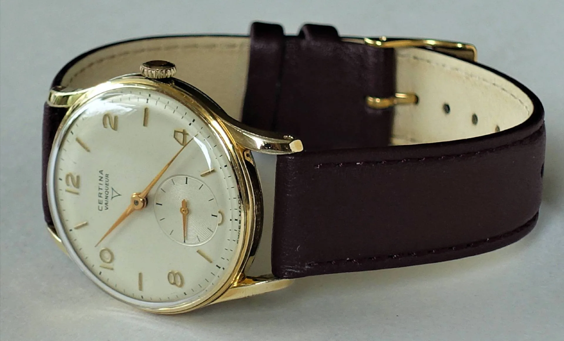 Klassische Armbanduhr mit goldfarbenem Gehäuse und braunem Lederarmband.
