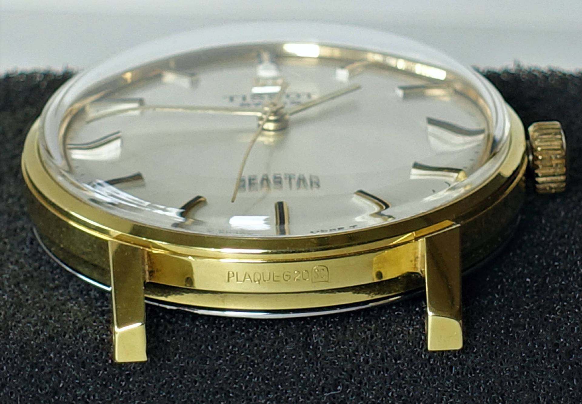 Goldfarbene Armbanduhr mit hellem Zifferblatt und silberfarbenen Indizes.
