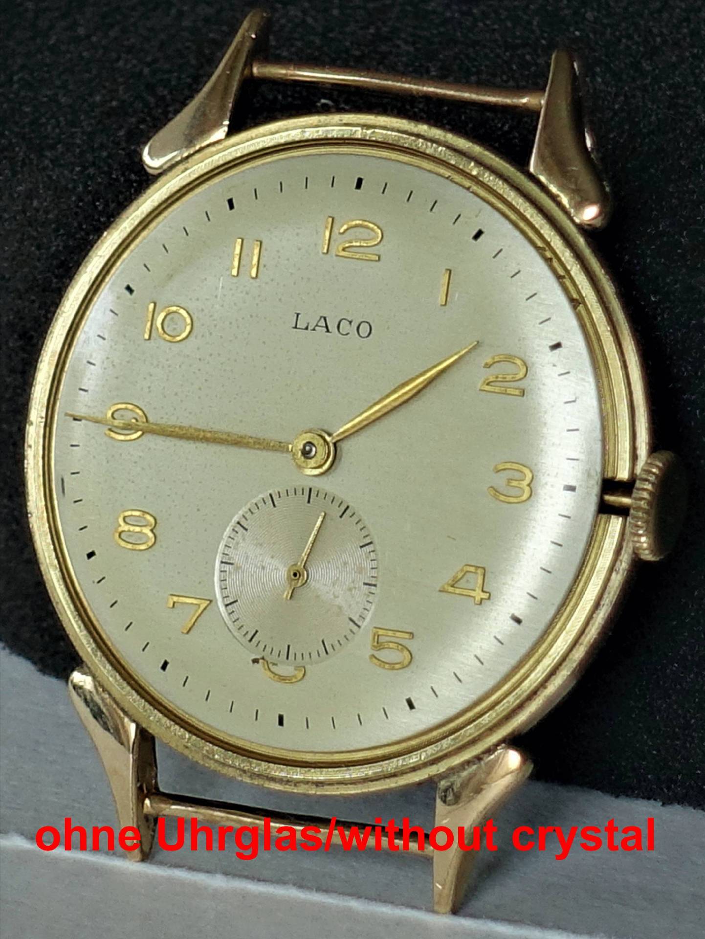 Goldfarbene Armbanduhr mit hellem Zifferblatt und goldenen Zahlen, ohne Uhrglas.