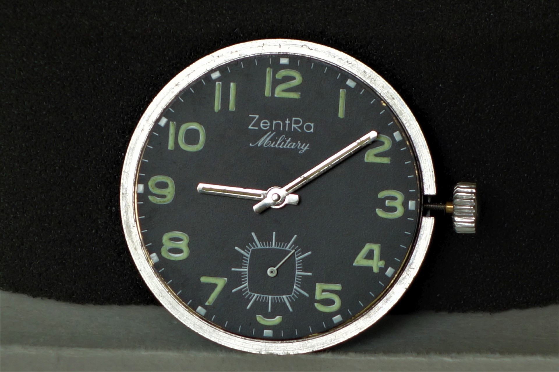 Schwarzes Uhrwerk mit Leuchtzeigern und Ziffern, Aufschrift "ZentRa Military".