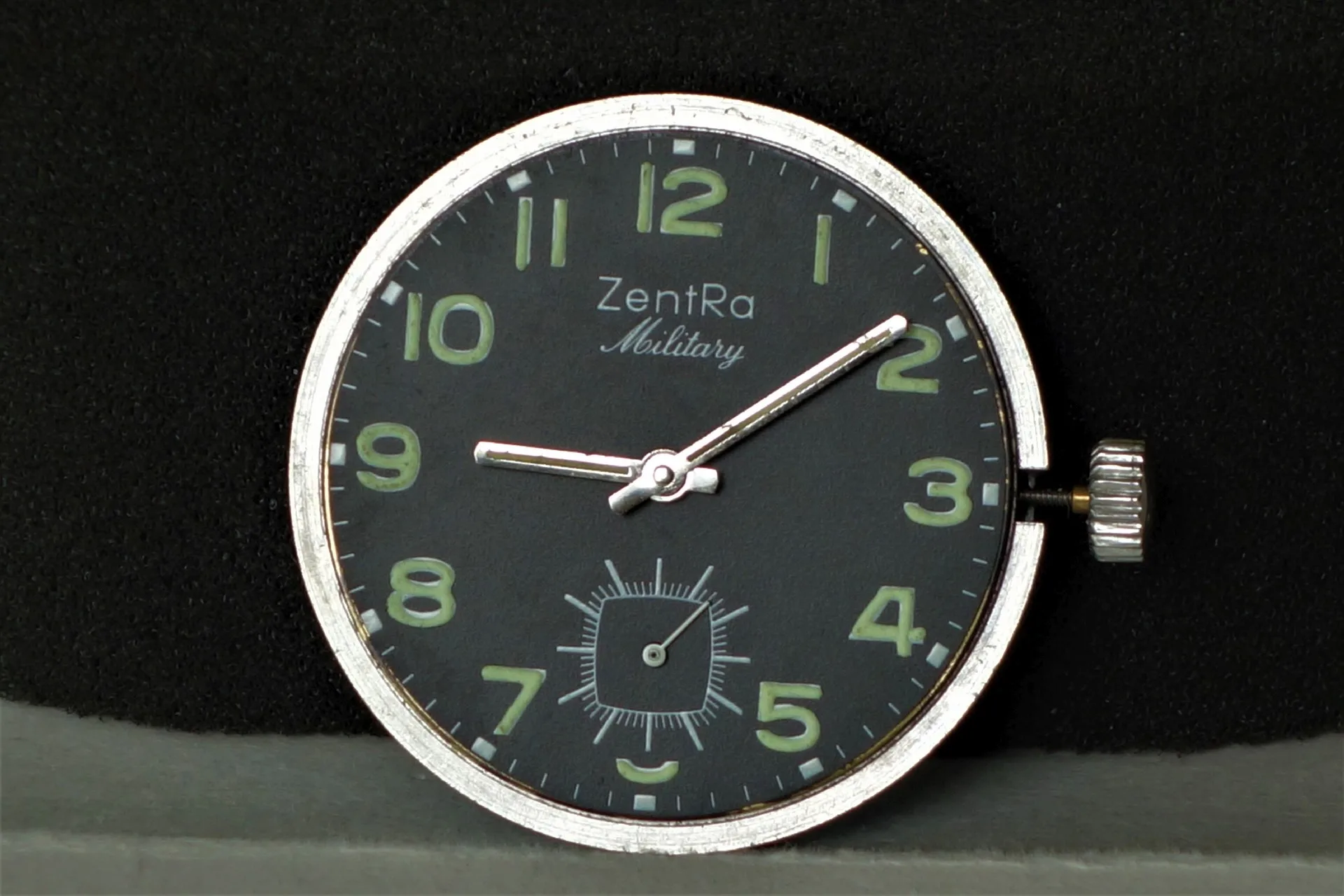 Schwarzes Uhrwerk mit Leuchtzeigern und Ziffern, Aufschrift "ZentRa Military".