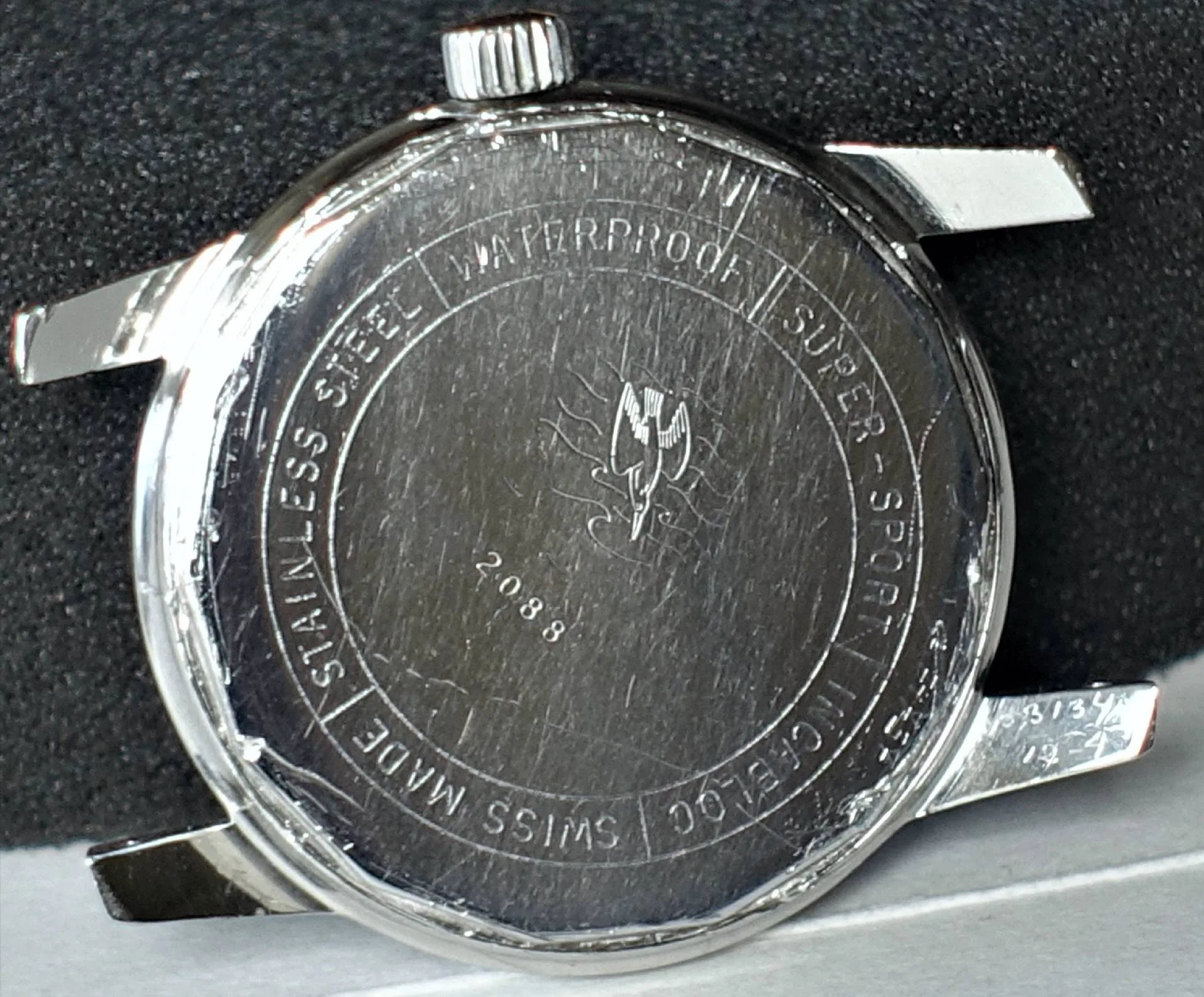 Rückseite einer wasserdichten Edelstahl-Uhr mit Super Sport Kennzeichnung Detailaufnahme der Rückseite einer modernen Uhr aus Edelstahl, wasserdicht, mit dem Hinweis auf Super Sport und Schweizer Herstellung.