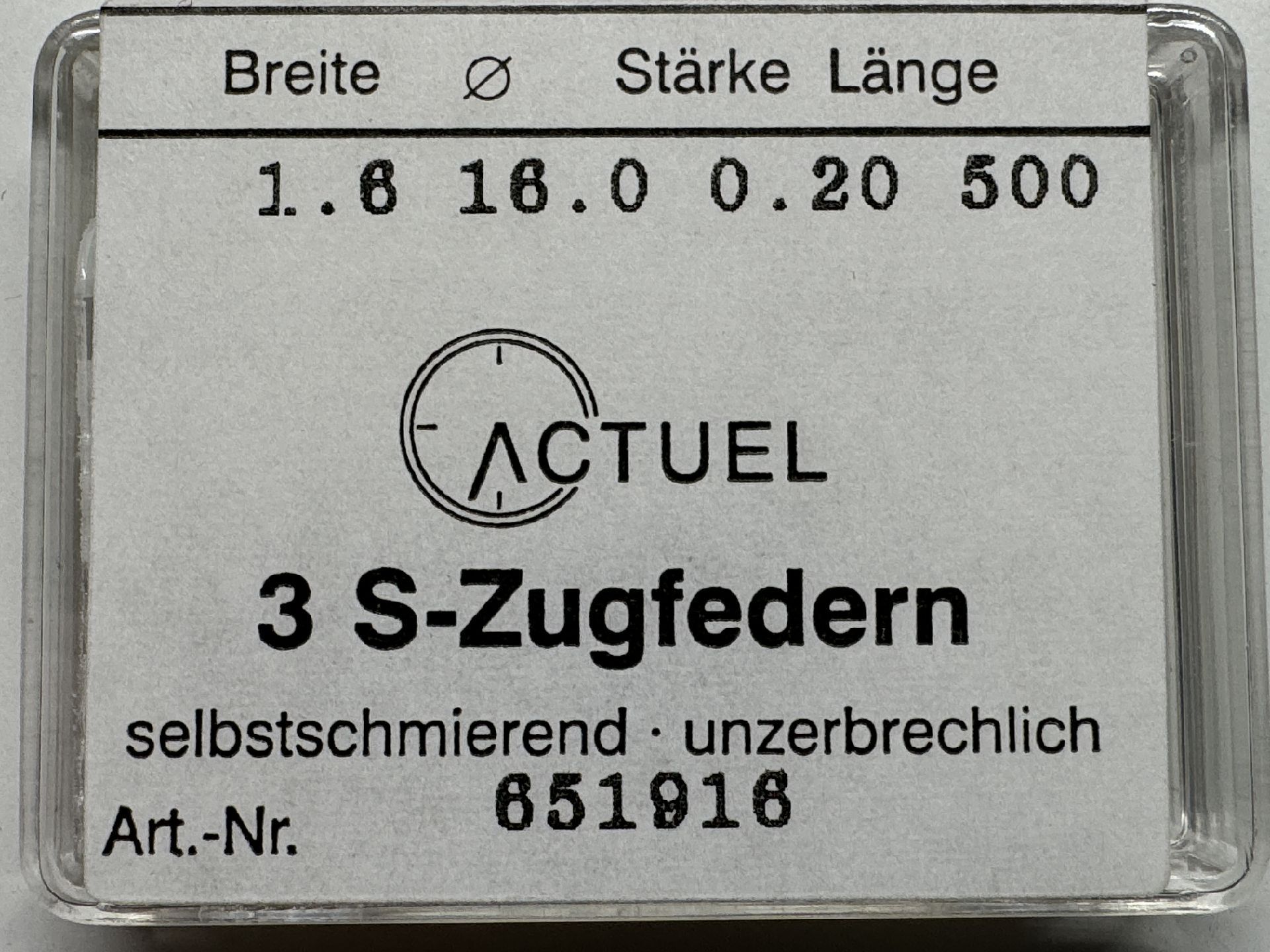 Drei silberfarbene Zugfedern für Uhren in transparenter Verpackung.