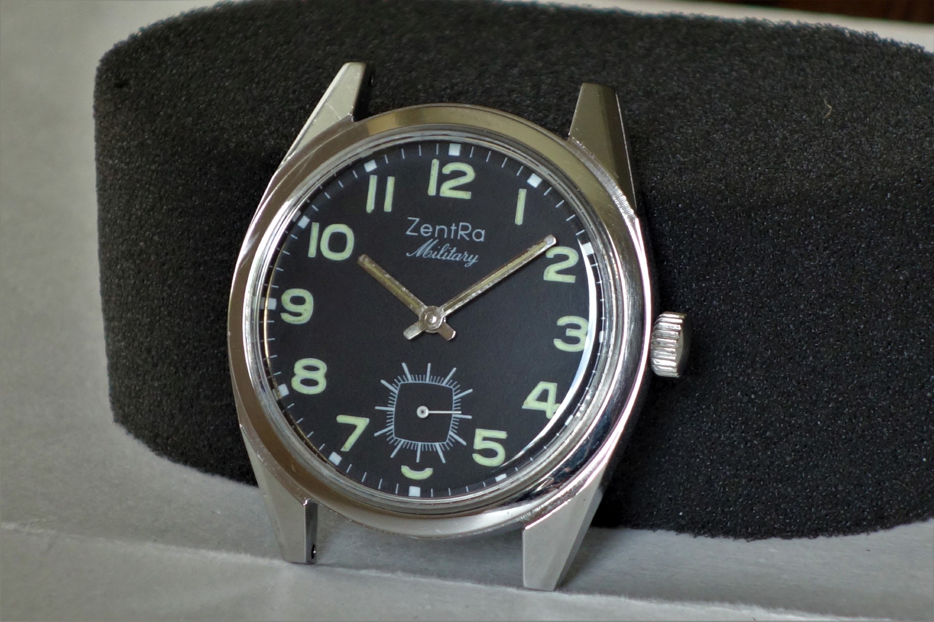 Schwarze Armbanduhr mit silberfarbenem Gehäuse und Leuchtziffern, Modell ZentRa Military.