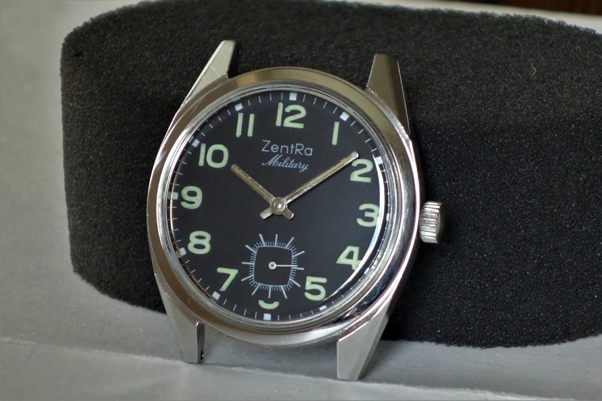 Schwarze Armbanduhr mit silberfarbenem Gehäuse und Leuchtziffern, Modell ZentRa Military.
