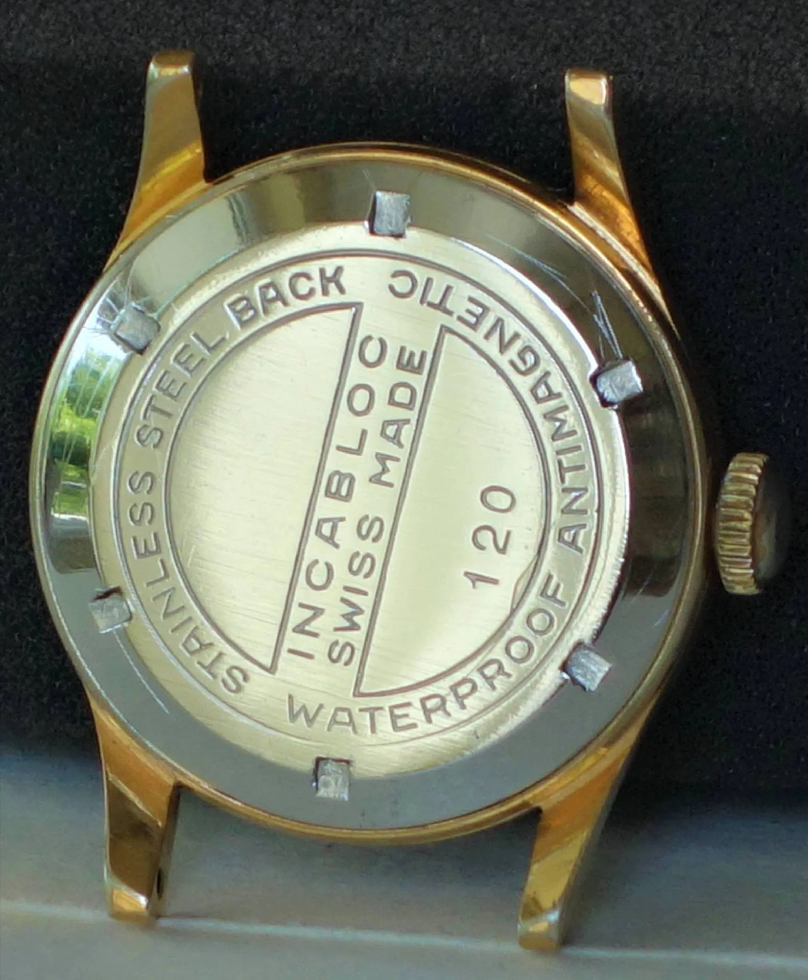 Goldfarbenes Uhrengehäuse mit silberfarbenem Edelstahlboden und Gravur "Incabloc Swiss Made".