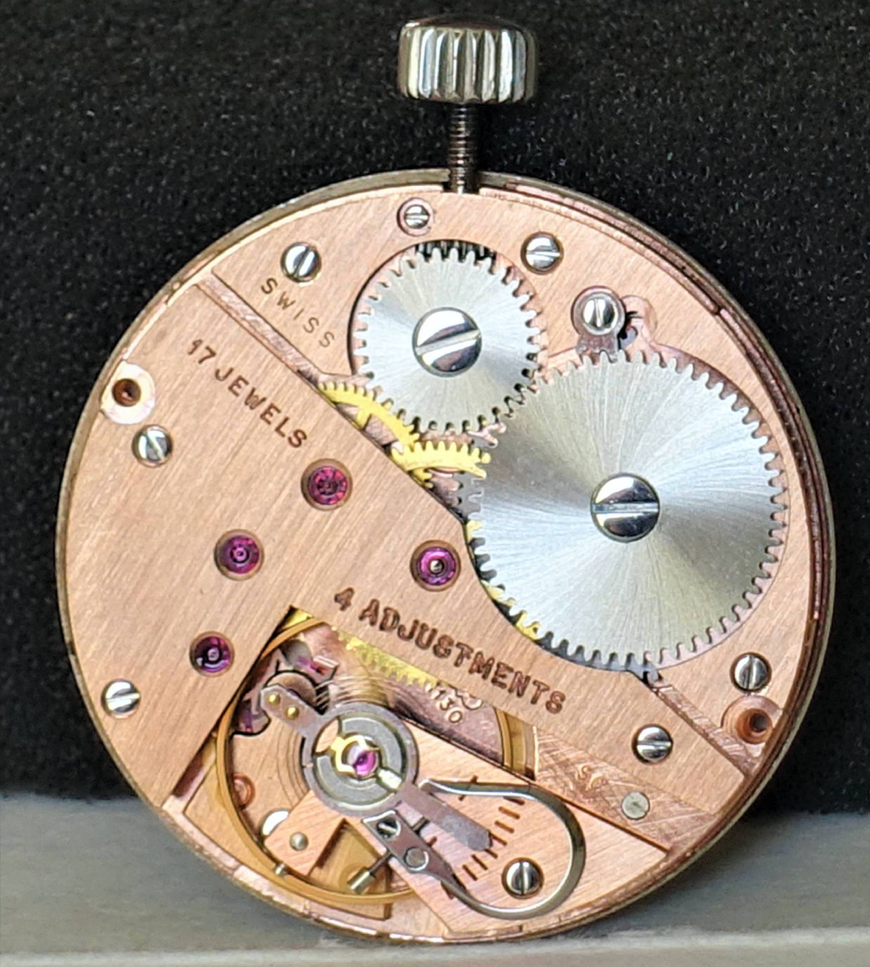 Detailaufnahme eines Uhrwerks mit Zahnrädern und Edelsteinen, das für mechanische Uhren verwendet wird.