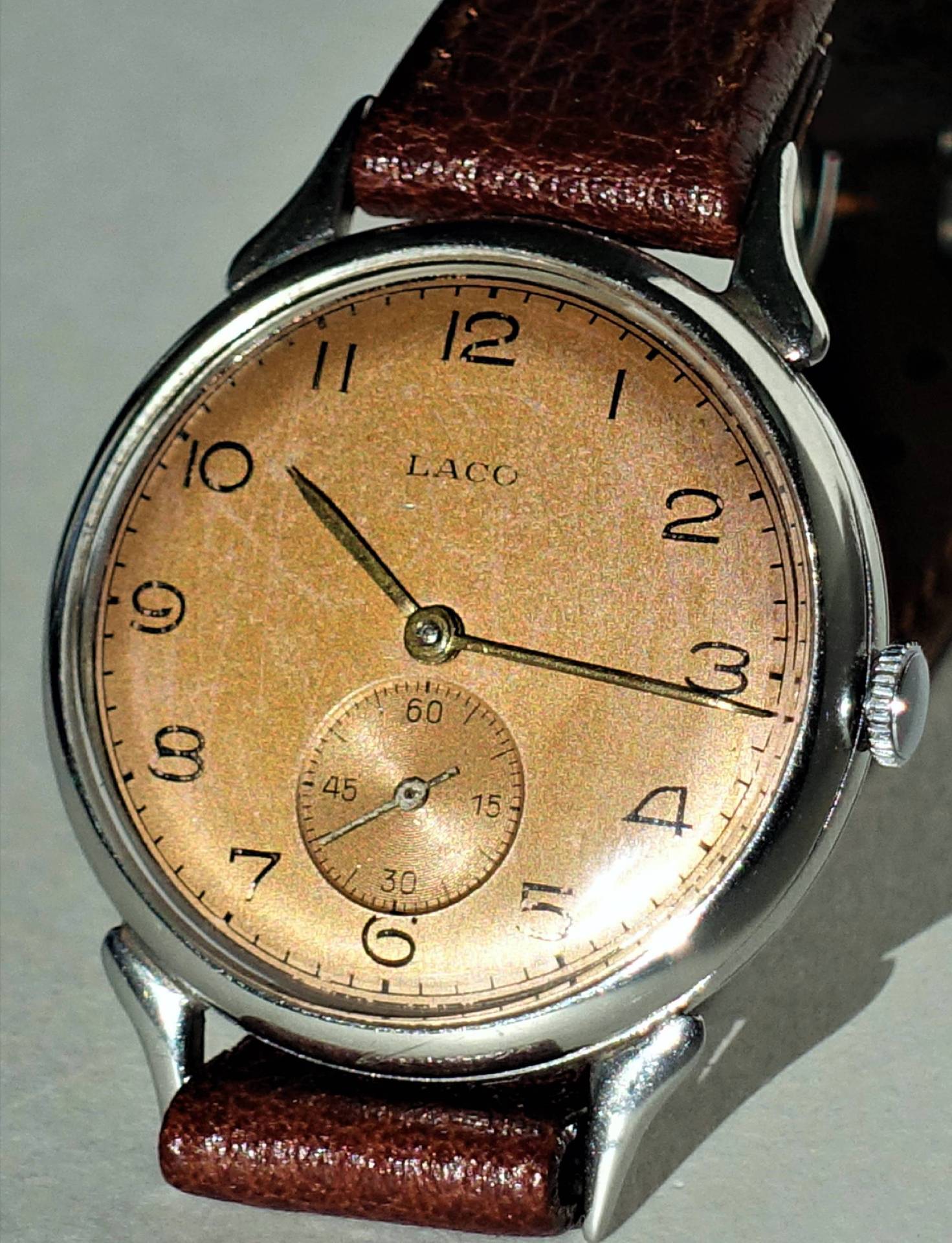 Armbanduhr mit braunem Zifferblatt, silberfarbenem Gehäuse und braunem Lederarmband.