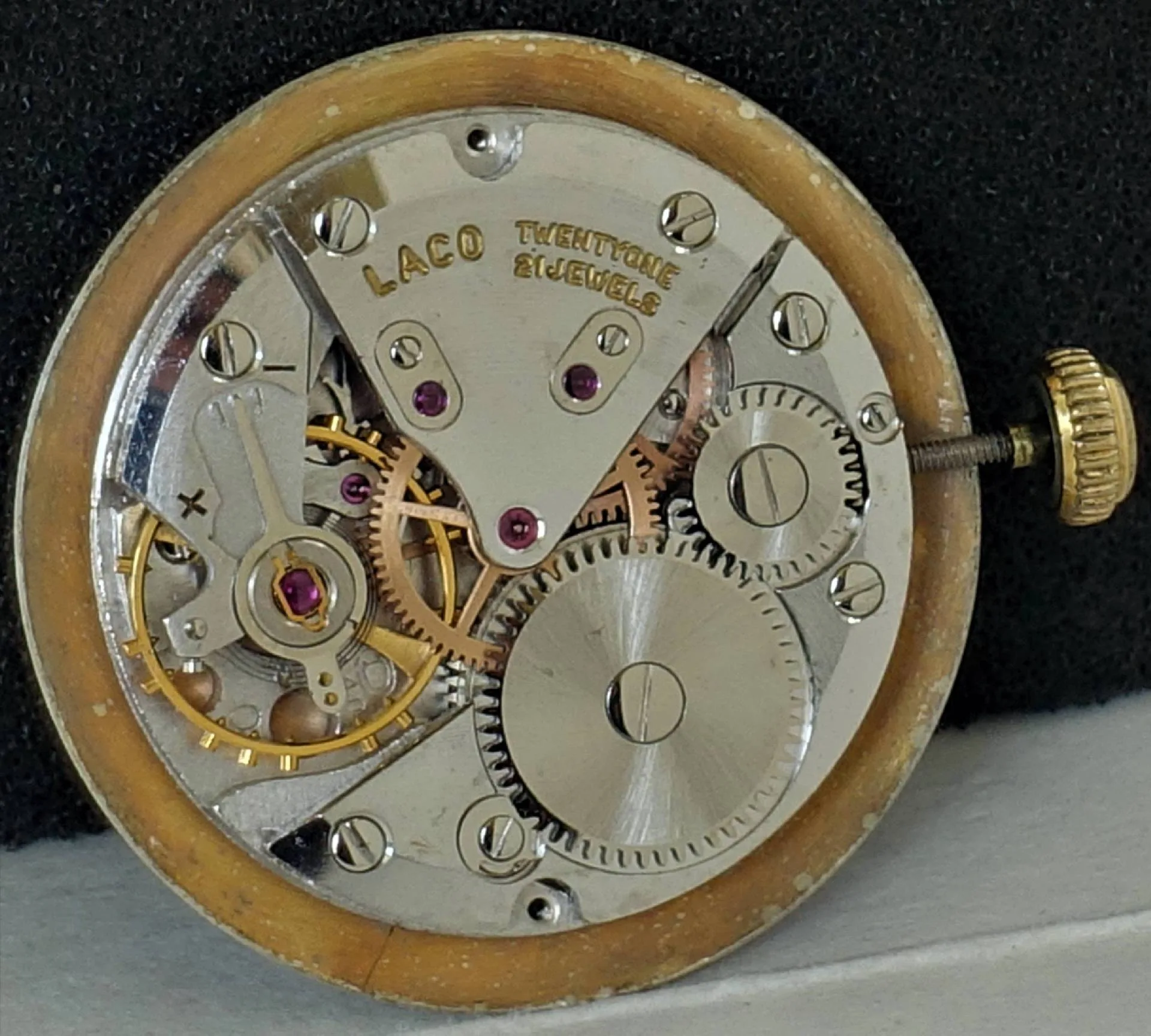 Mechanisches Uhrwerk mit sichtbaren Zahnrädern und goldfarbener Krone, Beschriftung "Laco Twentyone 21 Jewels".