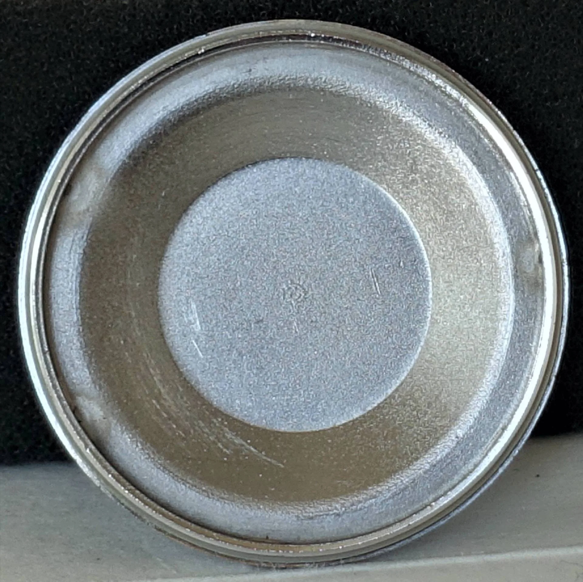 Silberfarbener Uhrendeckel innen Das Bild zeigt die Innenseite eines silberfarbenen Uhrendeckels, der rund und metallisch glänzend ist.