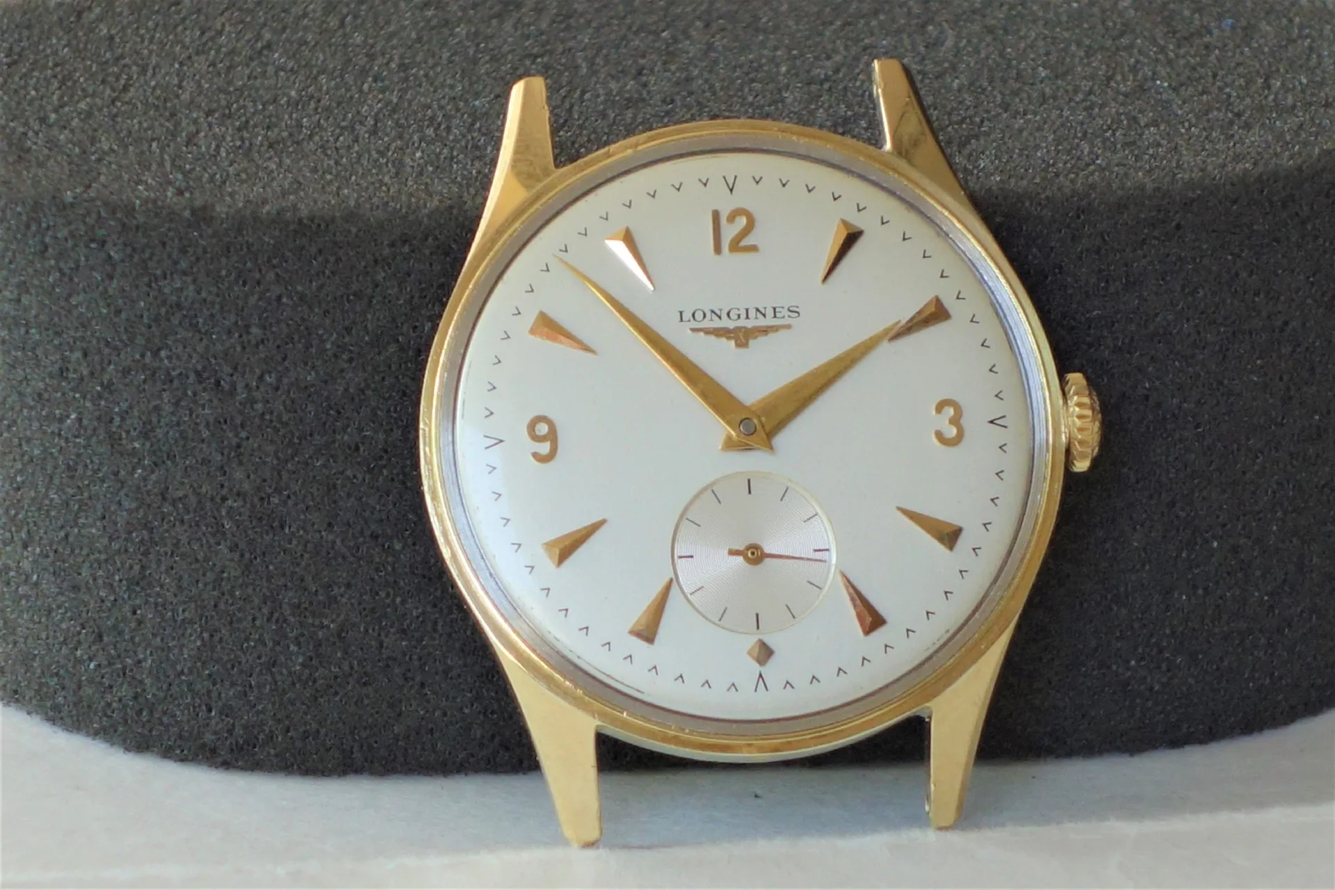 Longines Uhr goldfarben Analoge Armbanduhr mit goldfarbenem Gehäuse und weißen Zifferblatt, Marke Longines.