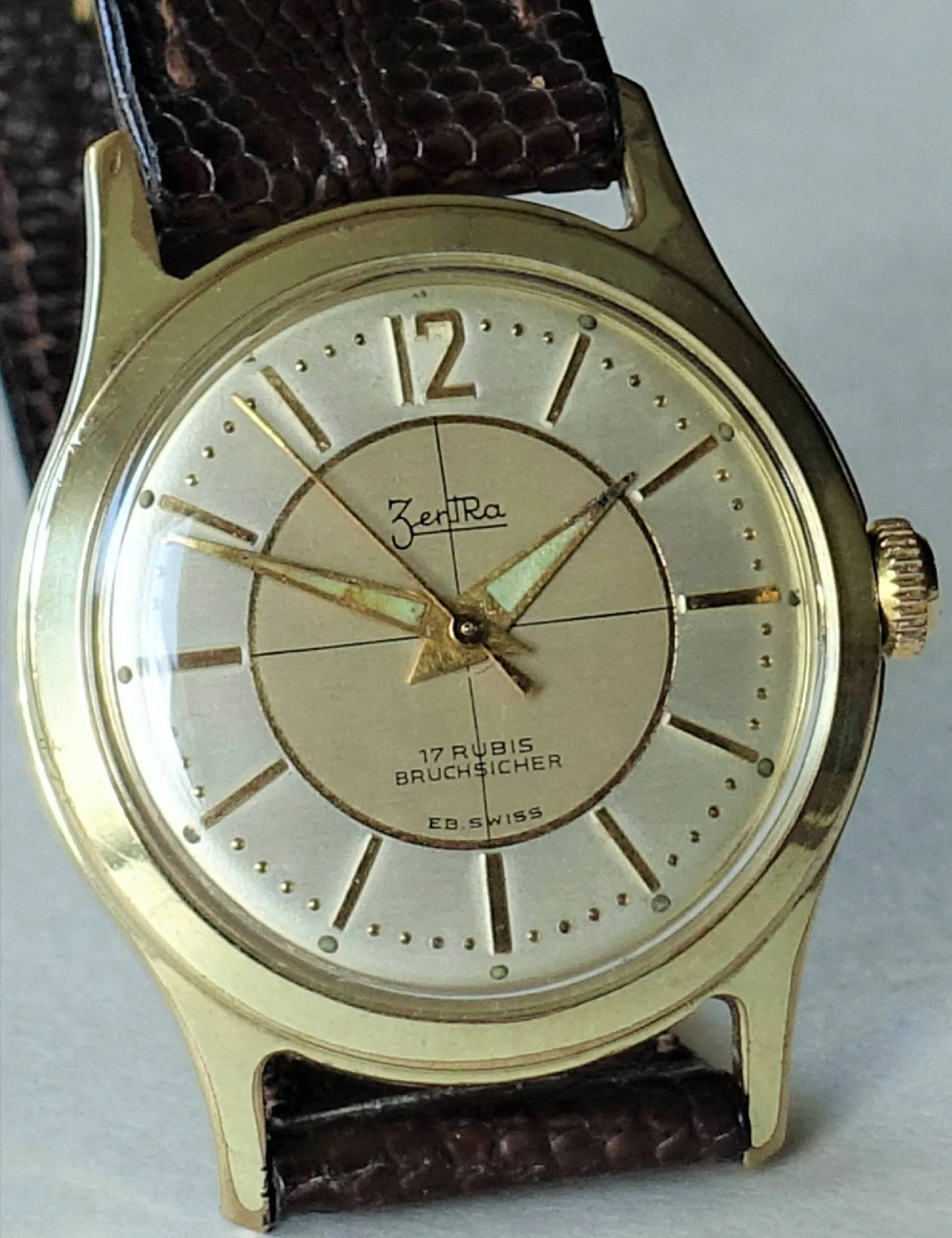 Armbanduhr goldfarben Goldfarbene Armbanduhr mit hellem Zifferblatt und braunem Armband.