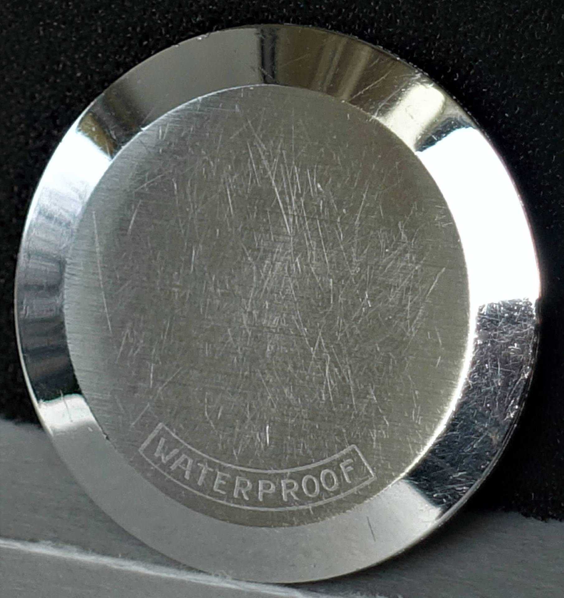 Silberfarbener Uhrenboden mit der Gravur "WATERPROOF".