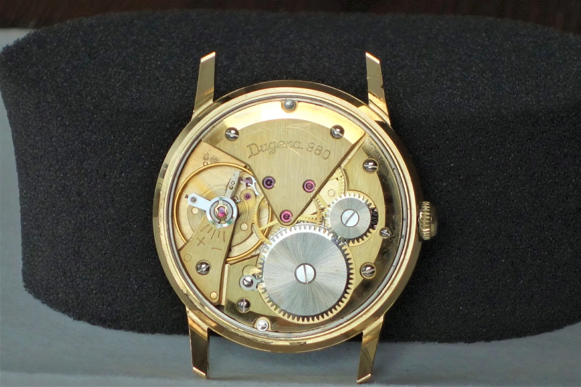 Mechanisches Uhrwerk in goldfarbener Ausführung mit sichtbaren Zahnrädern und Gravur "Dugena 980".