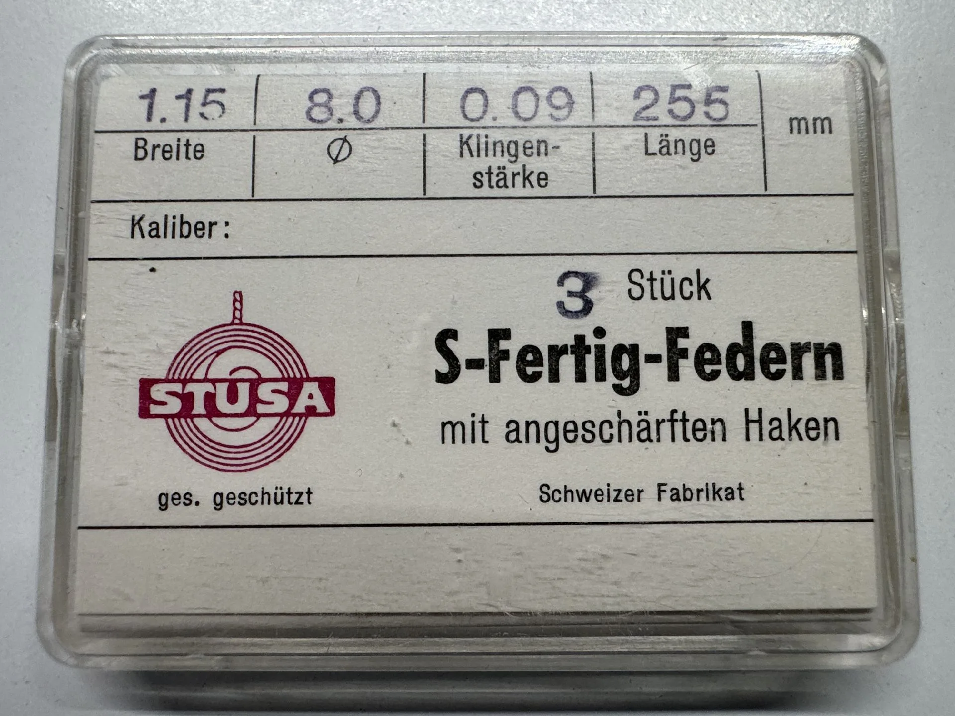 S-Fertig-Federn Set Verpackung mit drei silberfarbenen S-Fertig-Federn für Uhren mit angeschärften Haken.