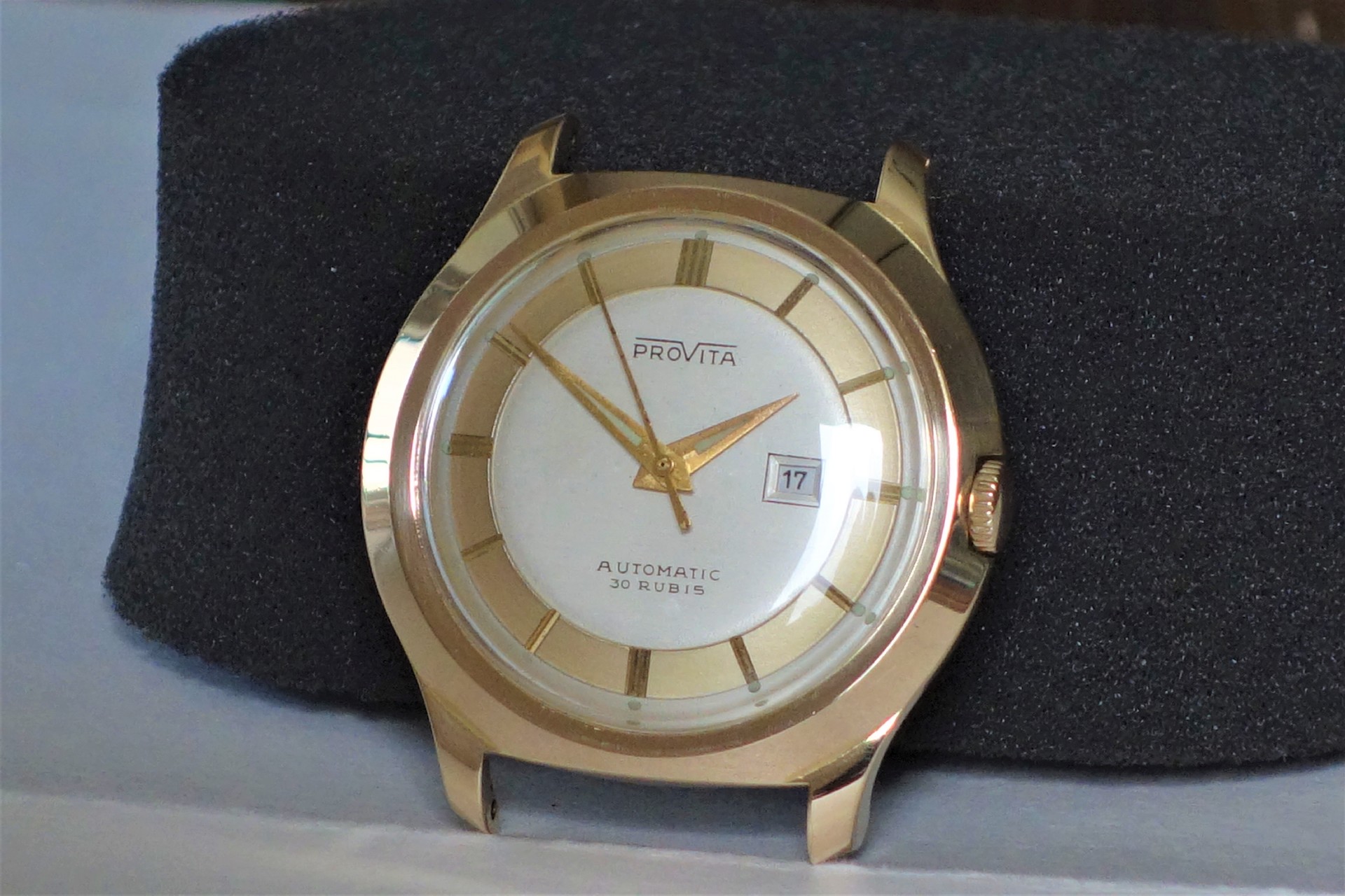 Goldfarbene Armbanduhr mit weißem Zifferblatt und Datumsanzeige.