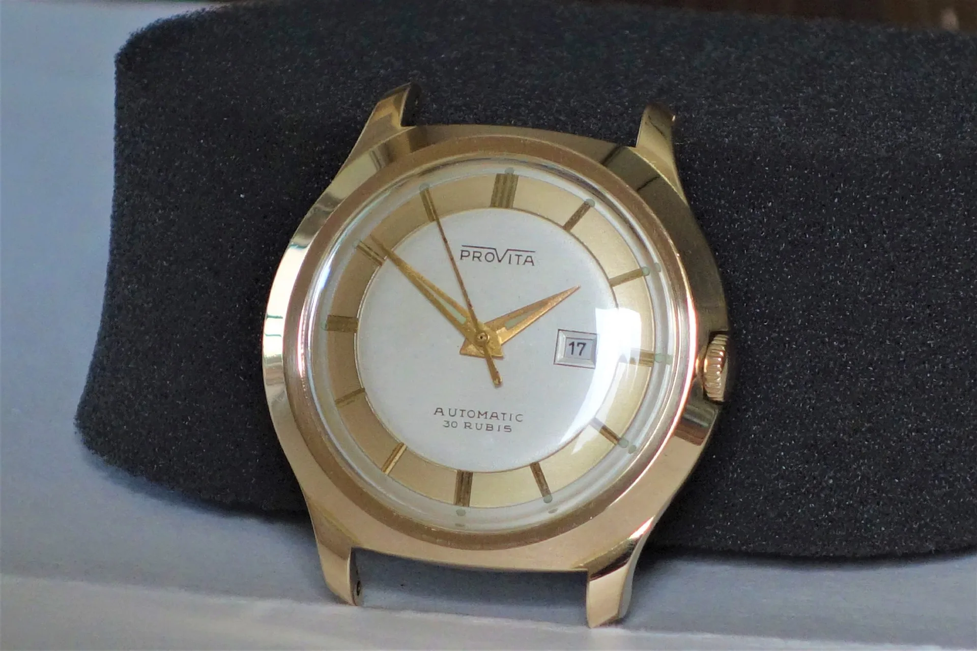 Automatik Uhr goldfarben Goldfarbene Armbanduhr mit weißem Zifferblatt und Datumsanzeige.
