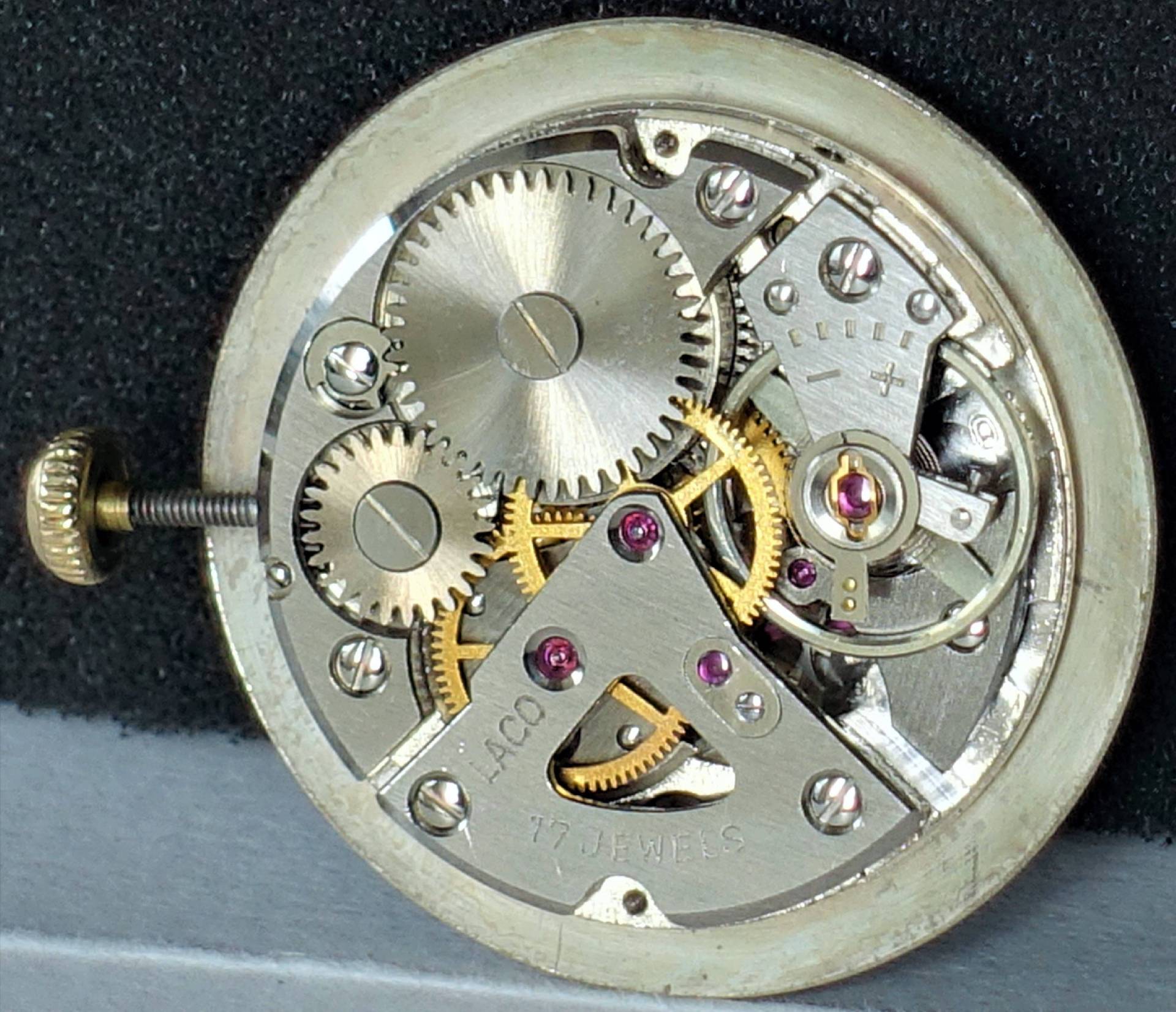 Mechanisches Uhrwerk mit sichtbaren Zahnrädern und Aufzugswelle, Gravur "Laco 17 Jewels" auf der Platine.