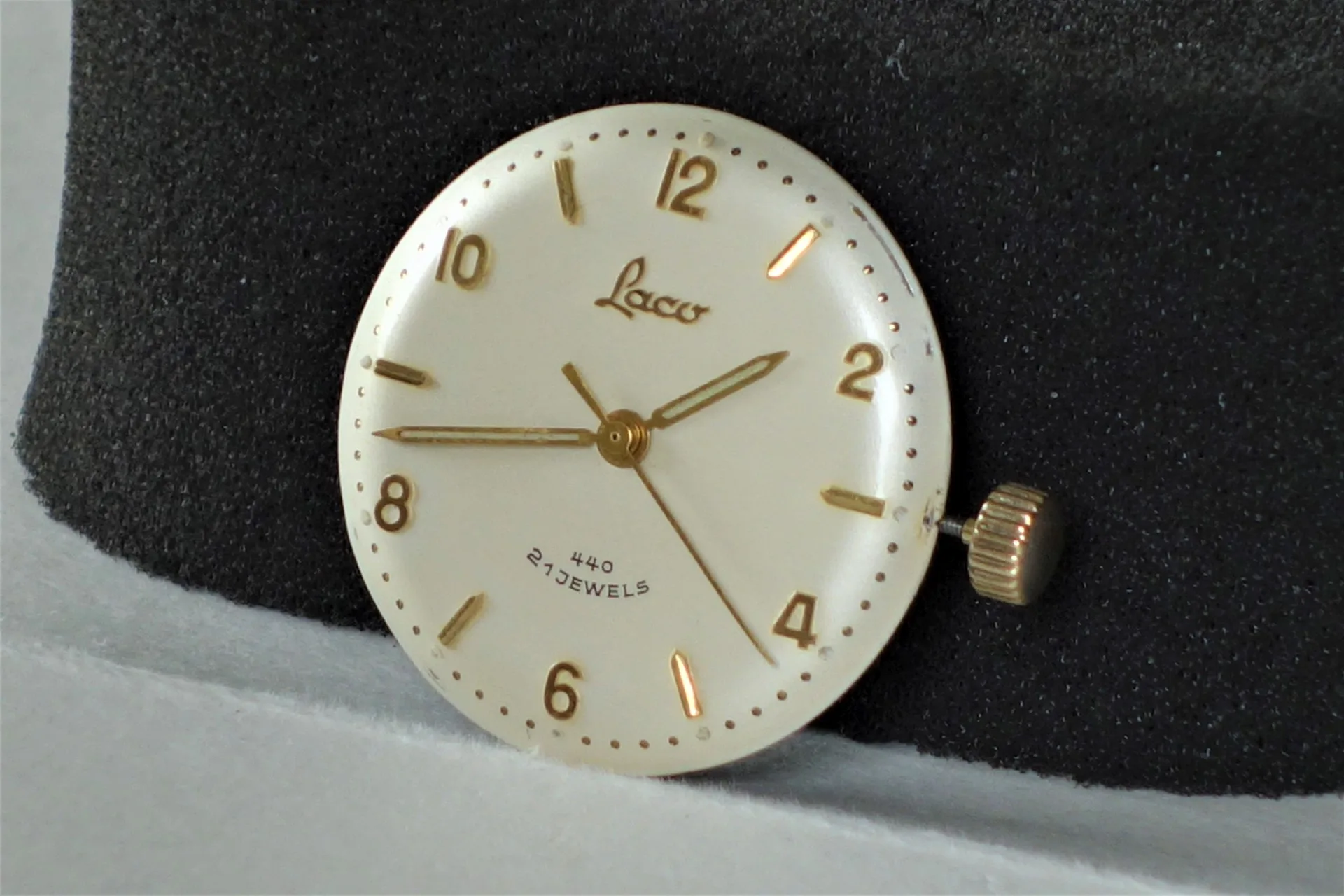 Uhrwerk Laco 440 Rundes Uhrwerk mit beigem Zifferblatt, goldfarbenen Zeigern und goldfarbener Krone.