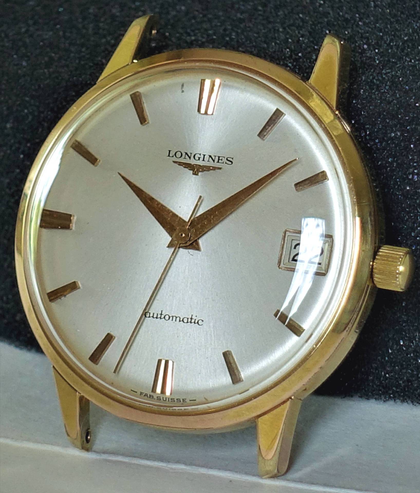 Goldfarbene Longines Armbanduhr mit silbernem Zifferblatt und Datumsanzeige.