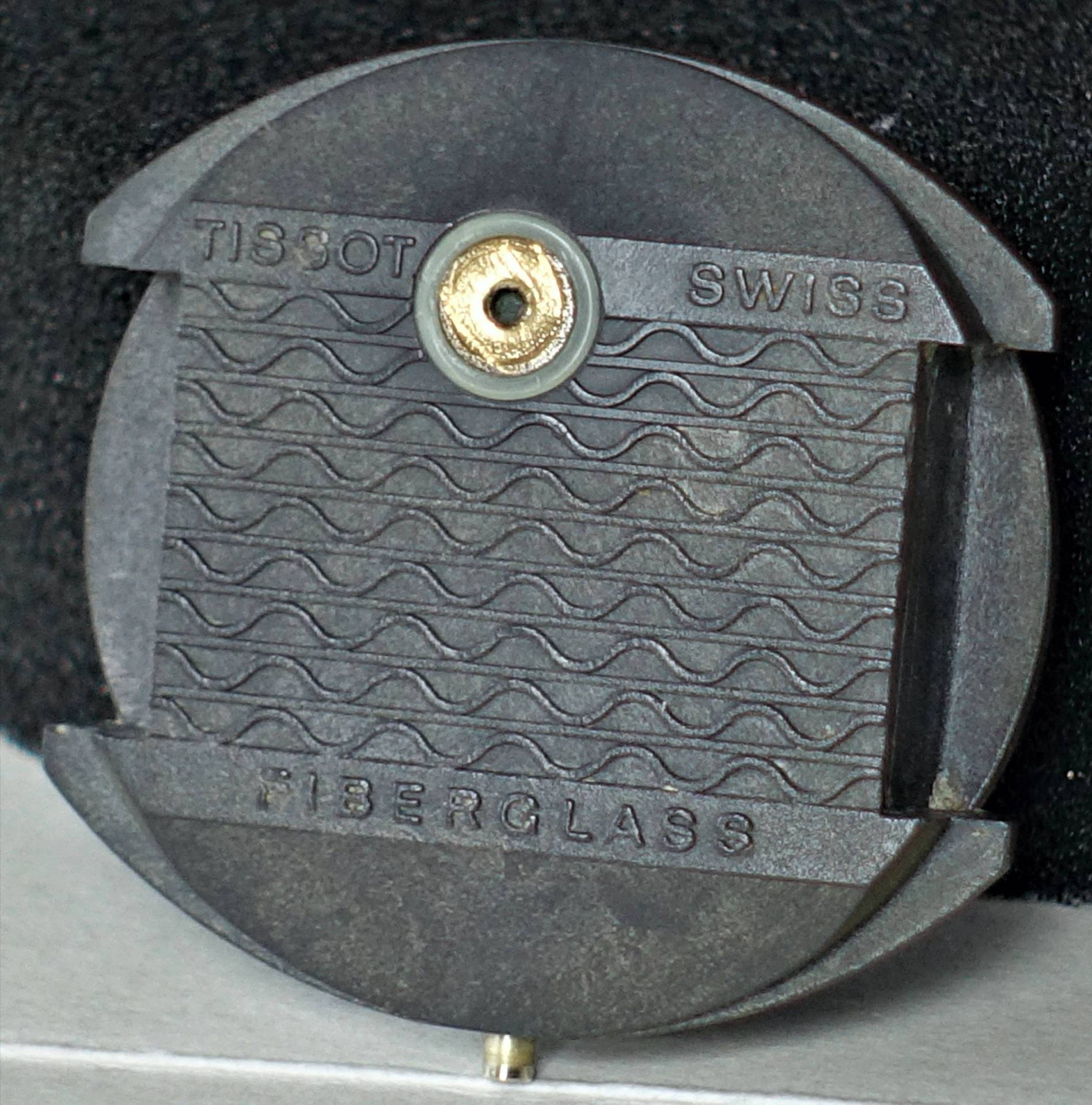 Schwarzer runder Uhrboden aus Fiberglas mit Tissot- und Swiss-Aufschrift.