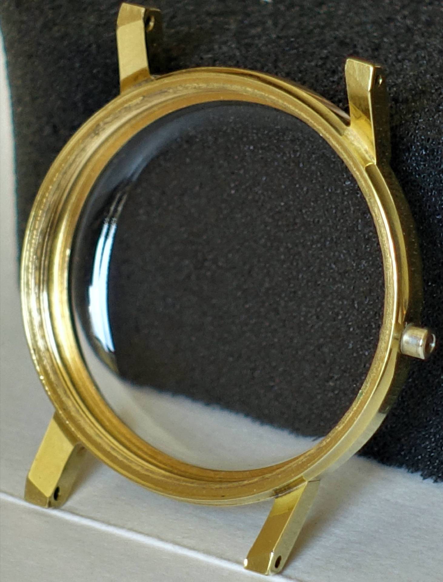 Rundes Uhrengehäuse in goldfarbener Optik mit montiertem Uhrglas.