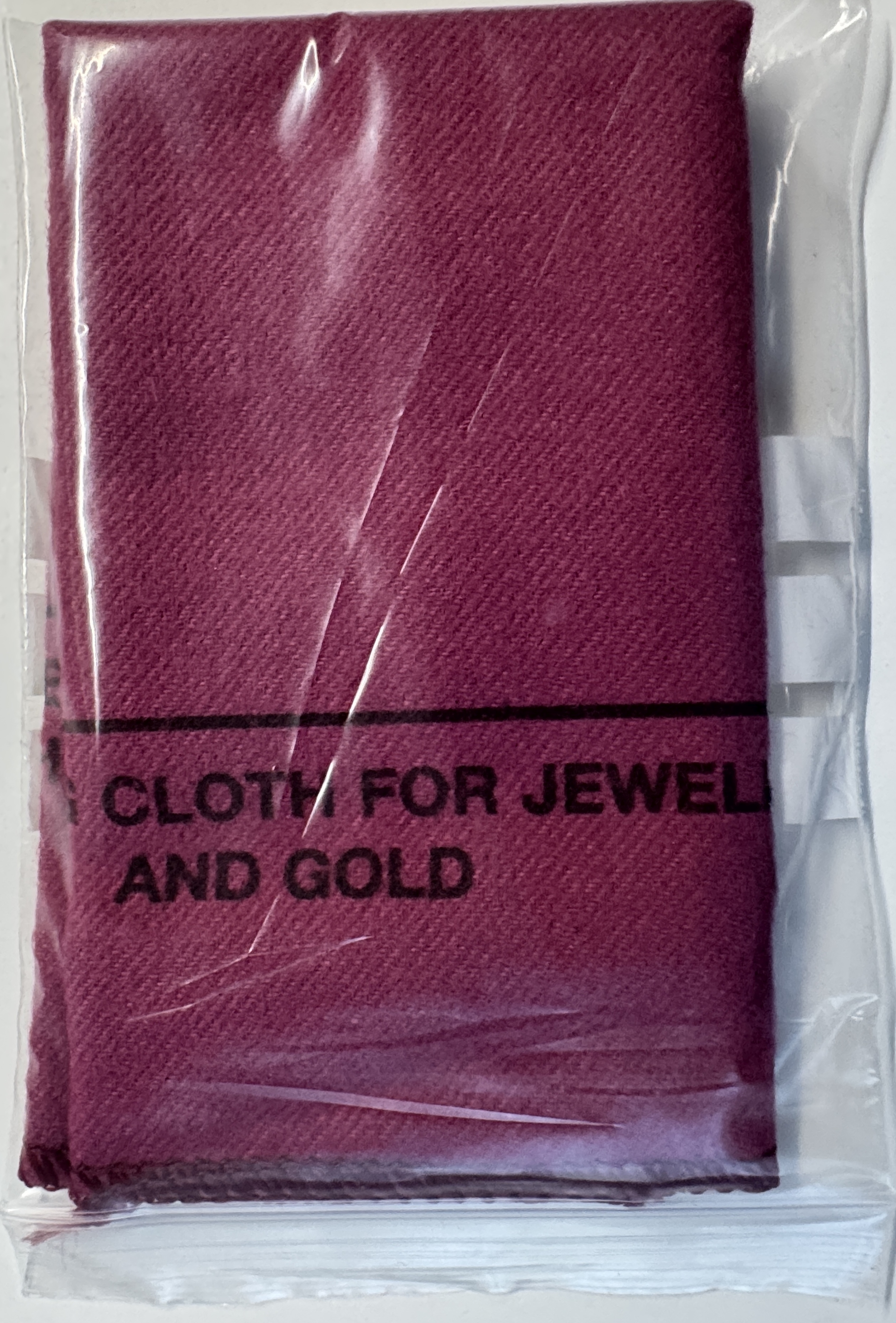 Reinigungstuch für Uhren Rotes Reinigungstuch aus Stoff in Plastikverpackung für Uhren und Schmuck.