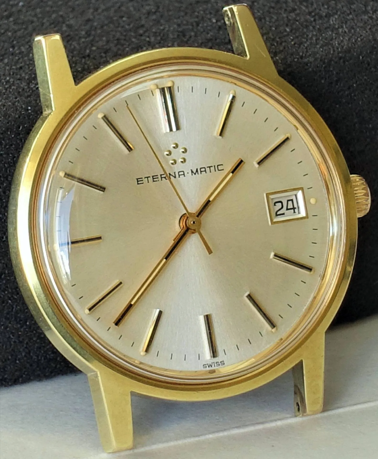 Goldfarbene Armbanduhr mit hellem Zifferblatt und Datumsanzeige.