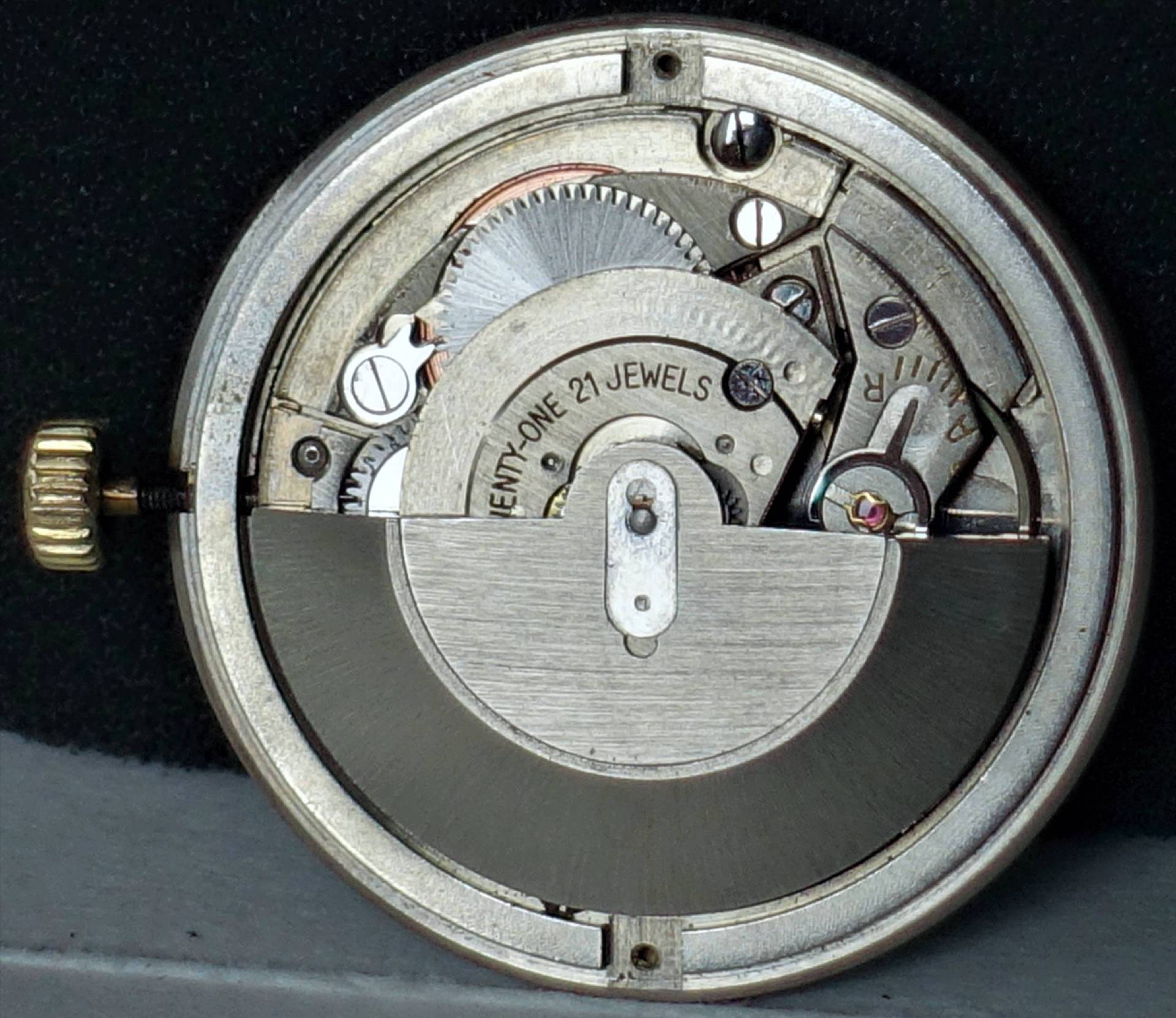 Silberfarbenes Automatik-Uhrwerk mit sichtbarem Rotor und goldfarbener Krone.