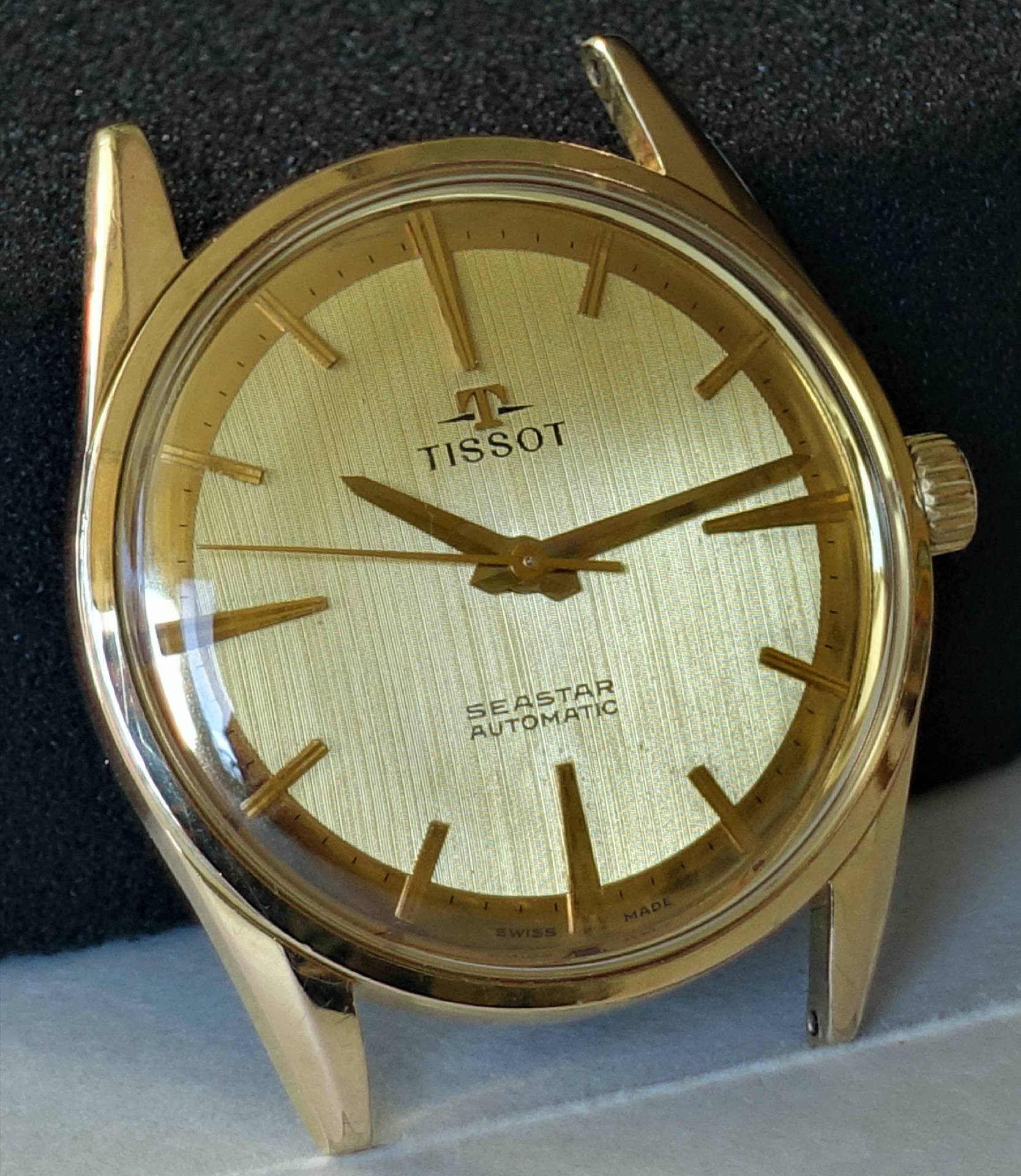 Goldfarbene Armbanduhr mit goldfarbenem Zifferblatt und Zeigern, Beschriftung "Tissot Seastar Automatic".