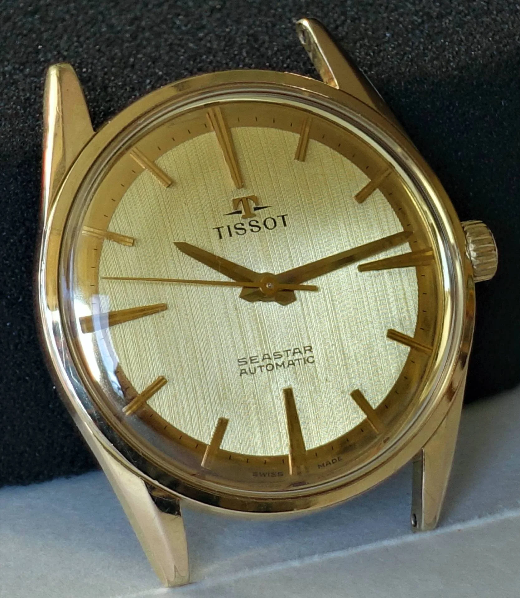 Goldfarbene Armbanduhr mit goldfarbenem Zifferblatt und Zeigern, Beschriftung "Tissot Seastar Automatic".