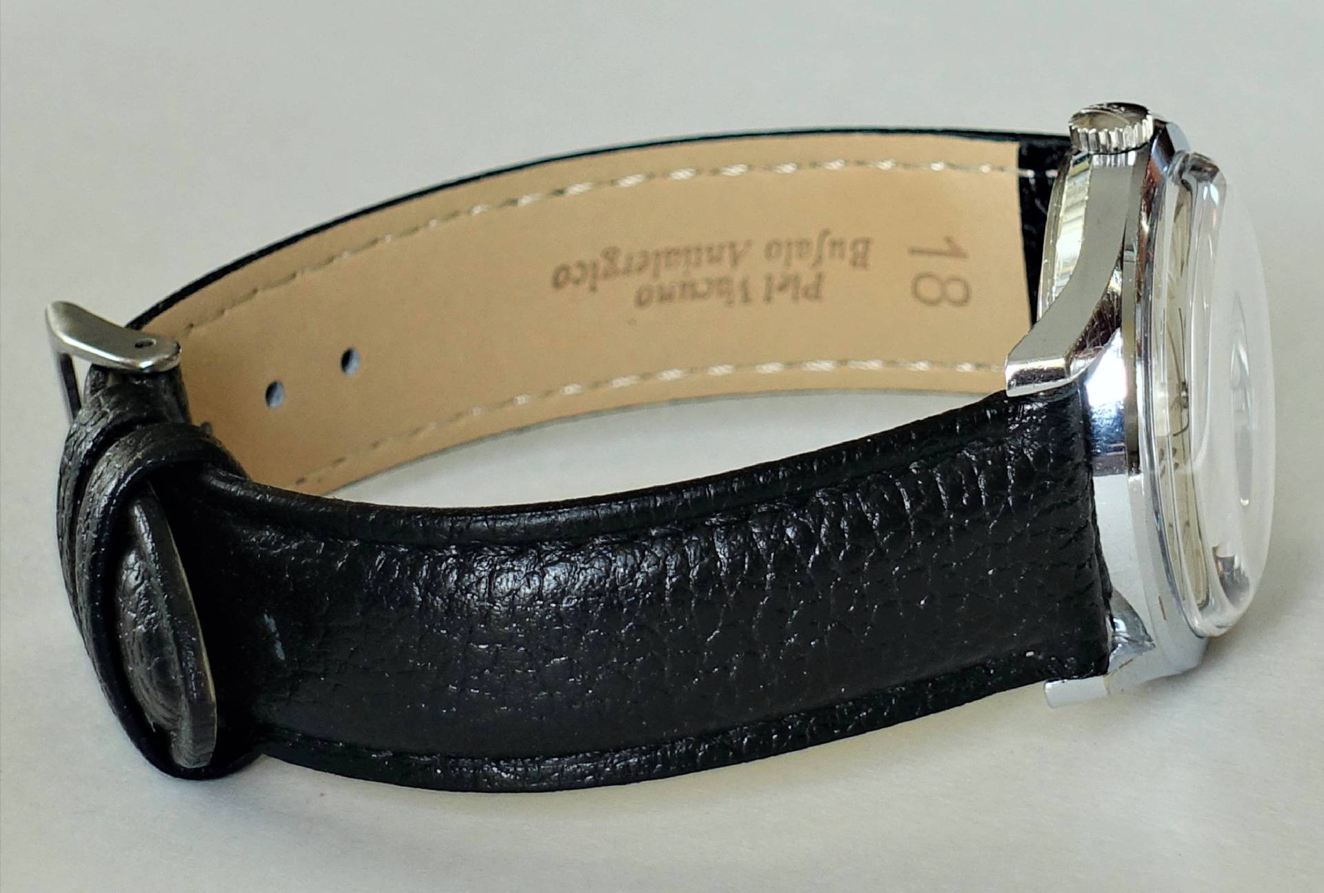 Armbanduhr mit schwarzem Lederarmband und silberfarbenem Gehäuse.