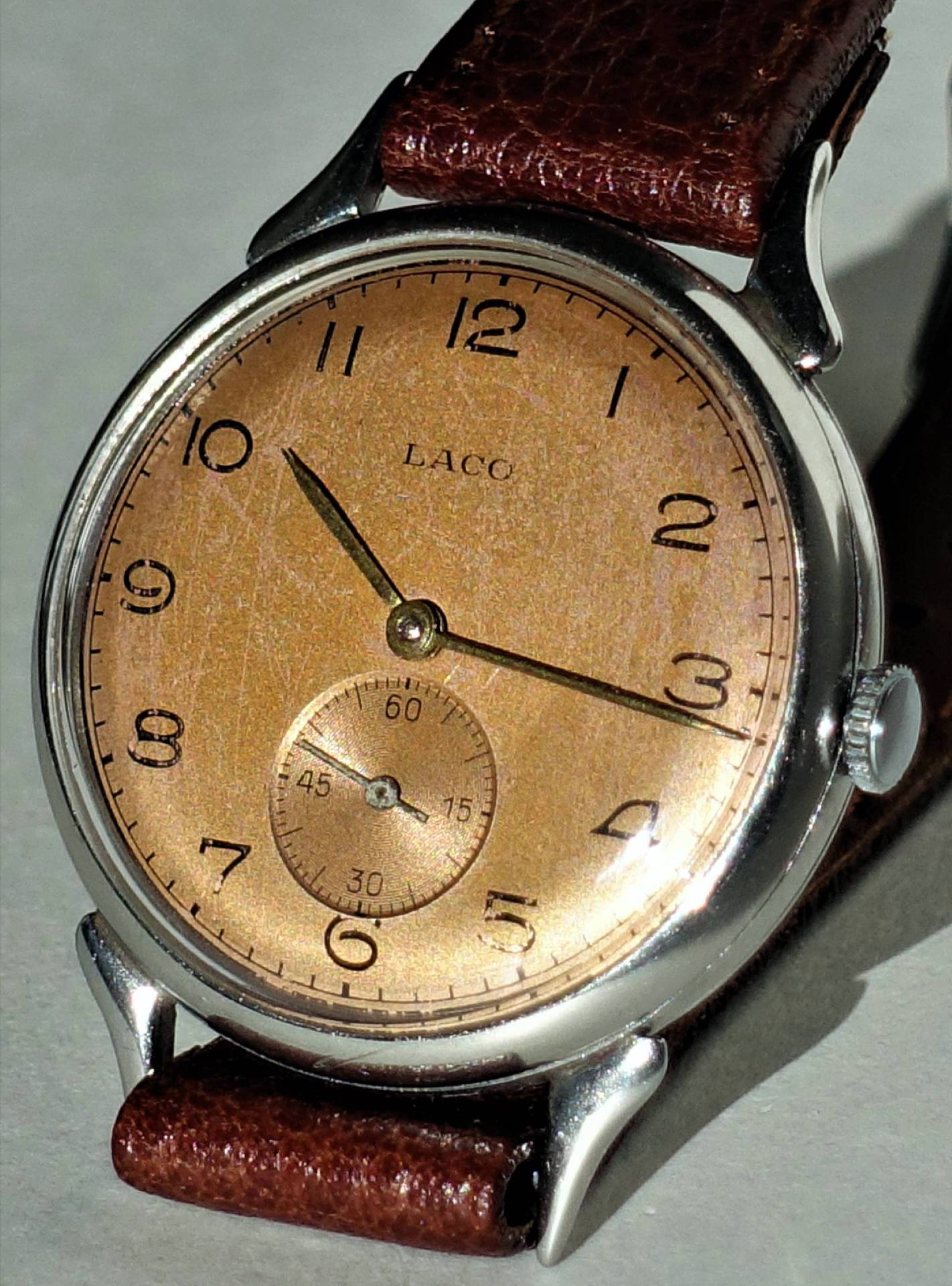 Braune Armbanduhr mit silberfarbenem Gehäuse und braunem Lederarmband, Zifferblatt mit kleiner Sekunde.