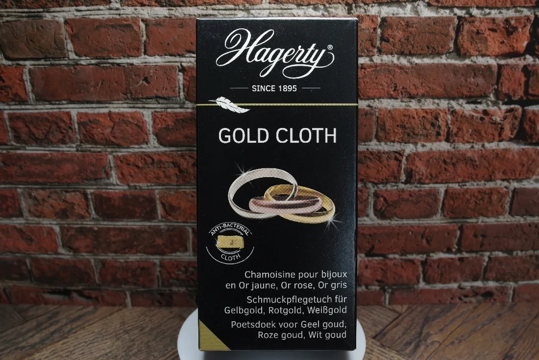 Schwarze Verpackung mit einem Tuch zur Reinigung von Schmuck aus Gelbgold, Rotgold und Weißgold.