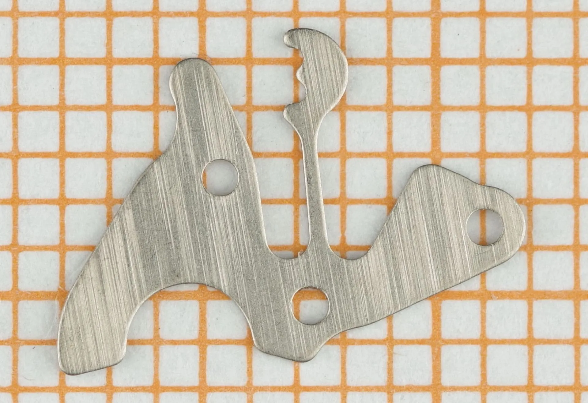 Flacher, silberfarbener Hebel aus Metall für ein Uhrwerk.