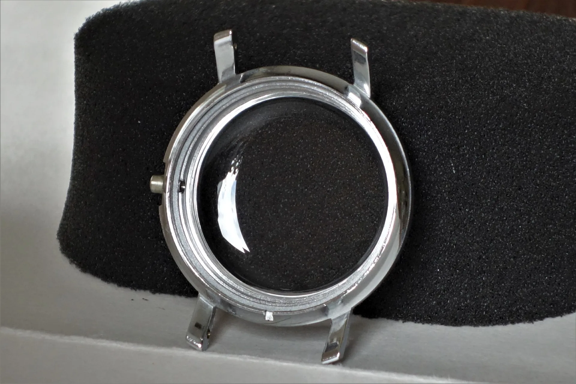 Rundes silberfarbenes Uhrengehäuse mit gewölbtem Glas.