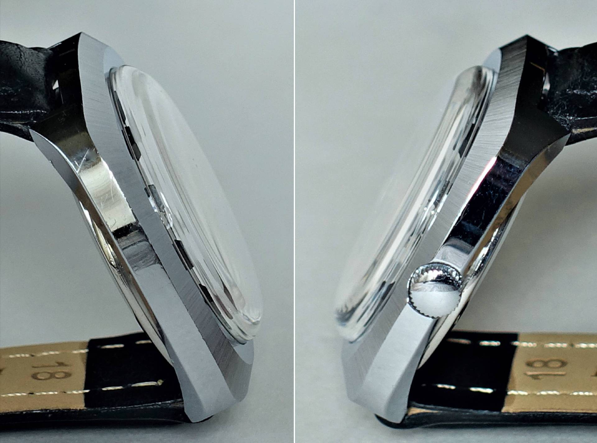 Silberfarbene Armbanduhr mit schwarzem Lederarmband, seitlich fotografiert.