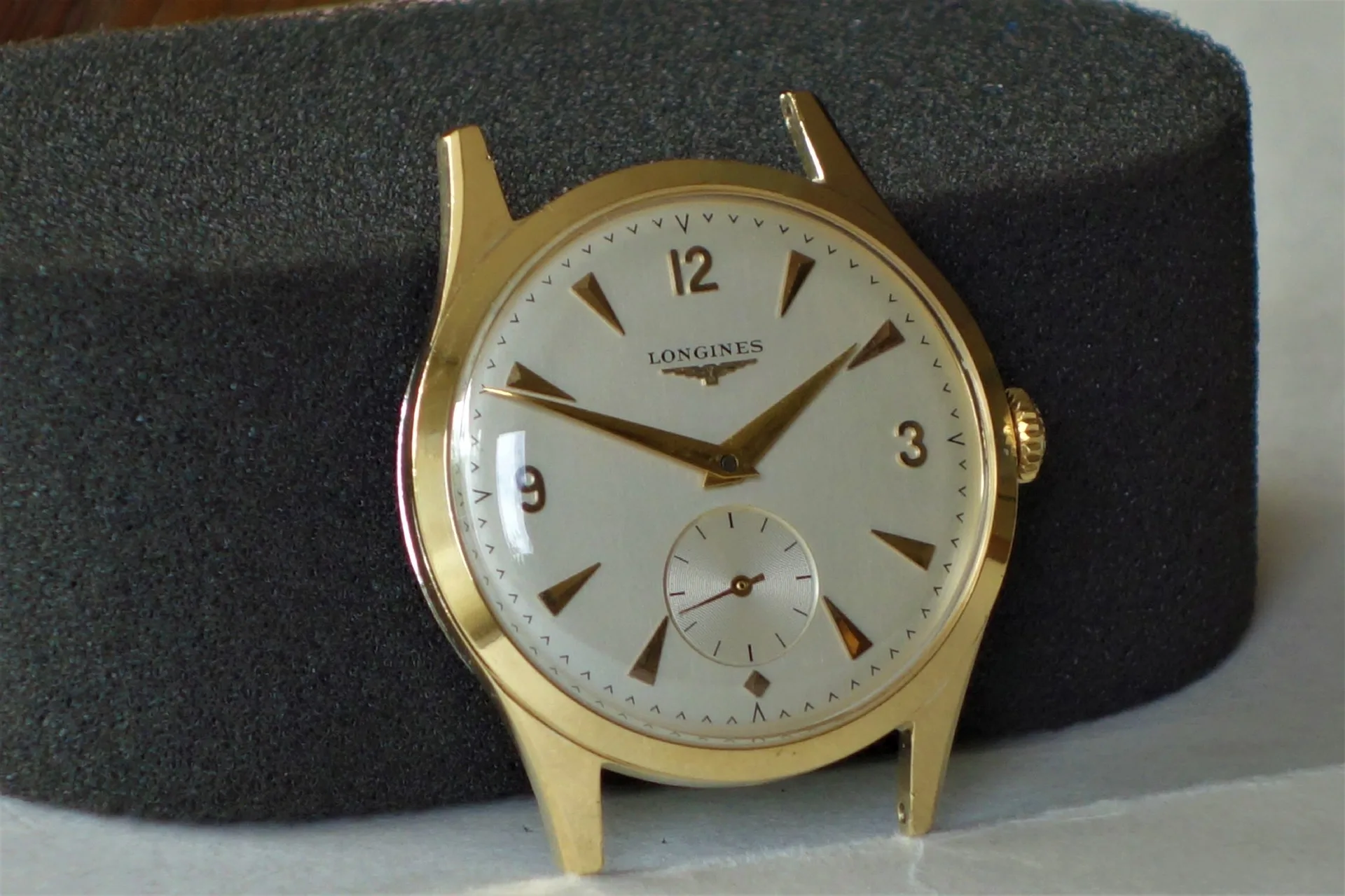 Goldfarbene Armbanduhr mit hellem Zifferblatt und kleiner Sekunde.