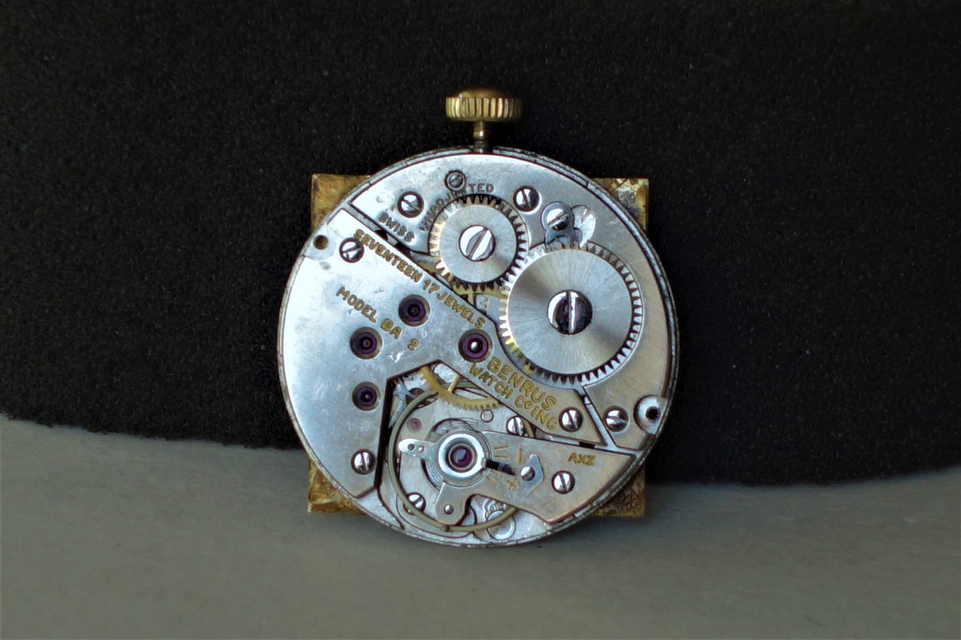 Mechanisches Uhrwerk aus Metall mit sichtbaren Zahnrädern und Aufzugswelle.