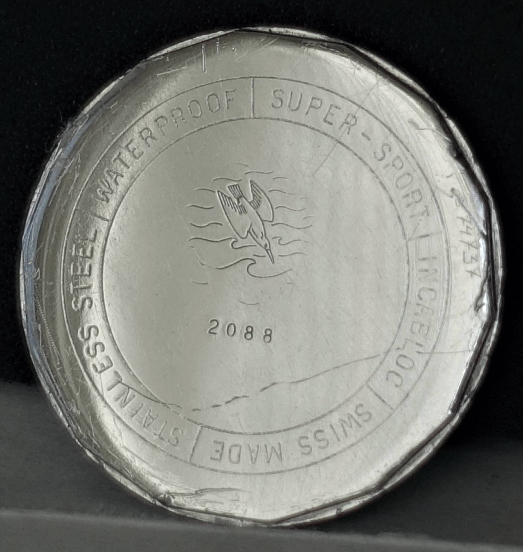 Uhrendesign aus Edelstahl mit Aufschrift über Wasserfestigkeit und Schweizer Herstellung