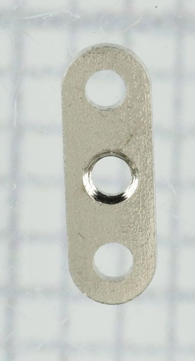 Kleine ovale Metallplatte mit drei Löchern für die Befestigung in Uhren.