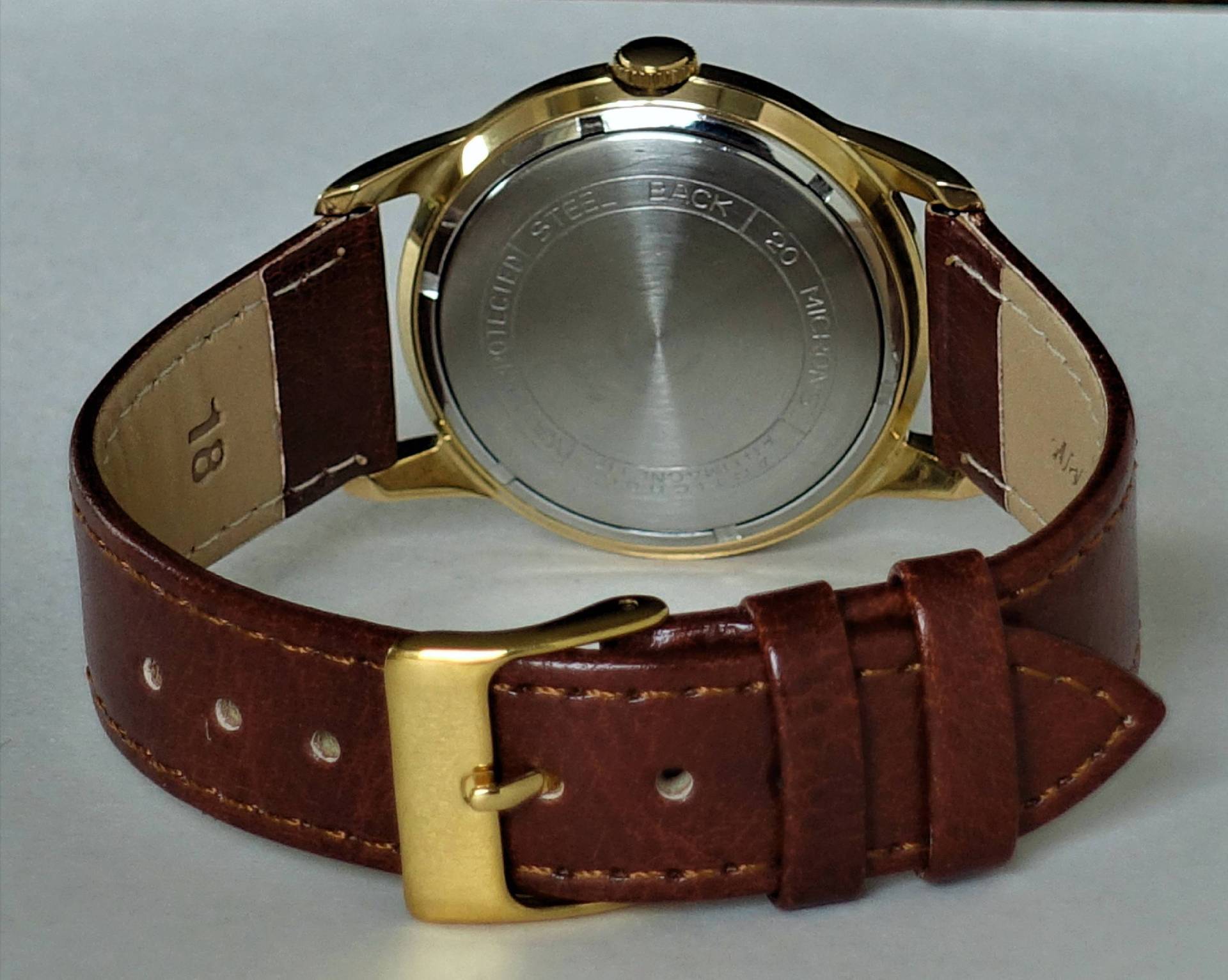 Armbanduhr mit braunem Armband und goldfarbenem Gehäuse, Rückseite sichtbar.