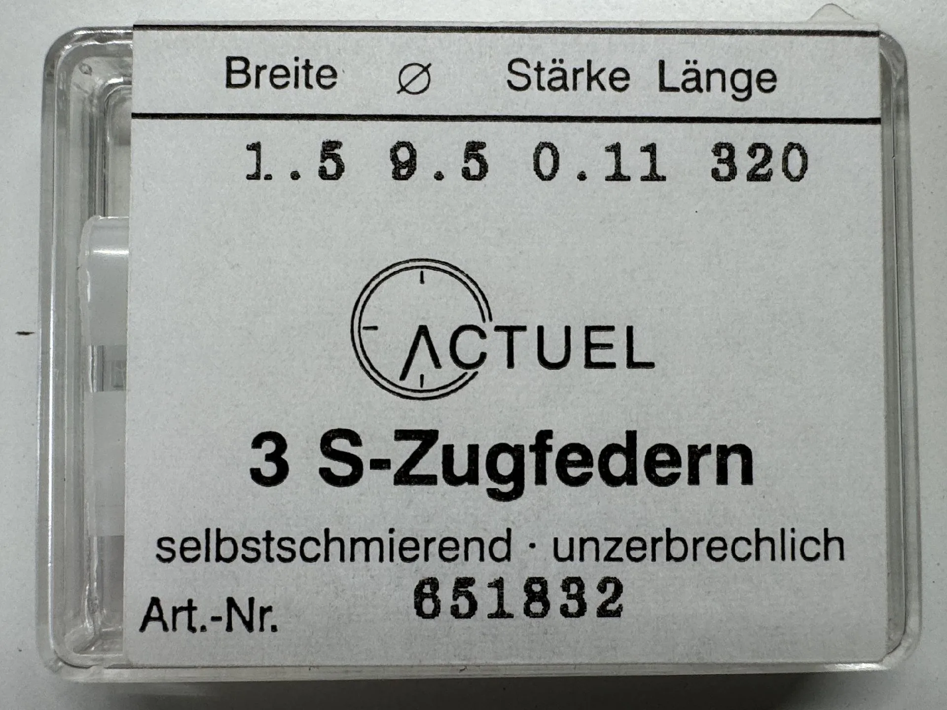 Drei silberfarbene Zugfedern für Uhren in transparenter Kunststoffbox.