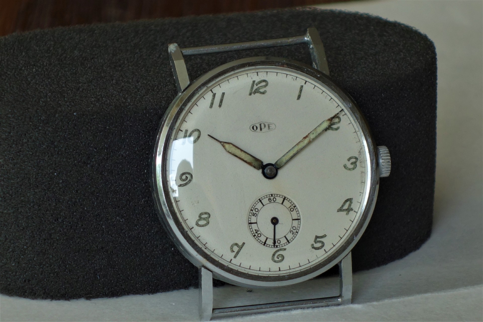 Silberfarbene mechanische Armbanduhr mit weißem Zifferblatt und kleiner Sekunde.